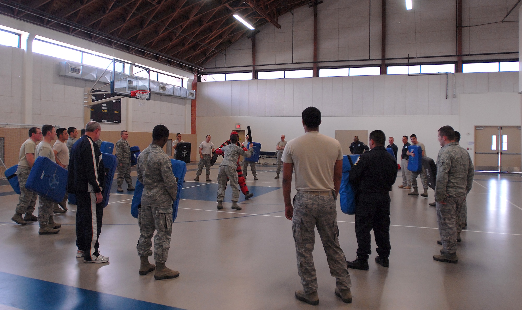 GOODFELLOW AIR FORCE BASE, Texas --Members of the 17th Security Forces Squadron form a barrier around the participants of the training drill Feb. 29, here. This training drill, consisting of defending against a mock assailant with a baton, is done yearly by Air Force Security Forces. (U.S. Air Force photo/Airman 1st Class Michael Smith)