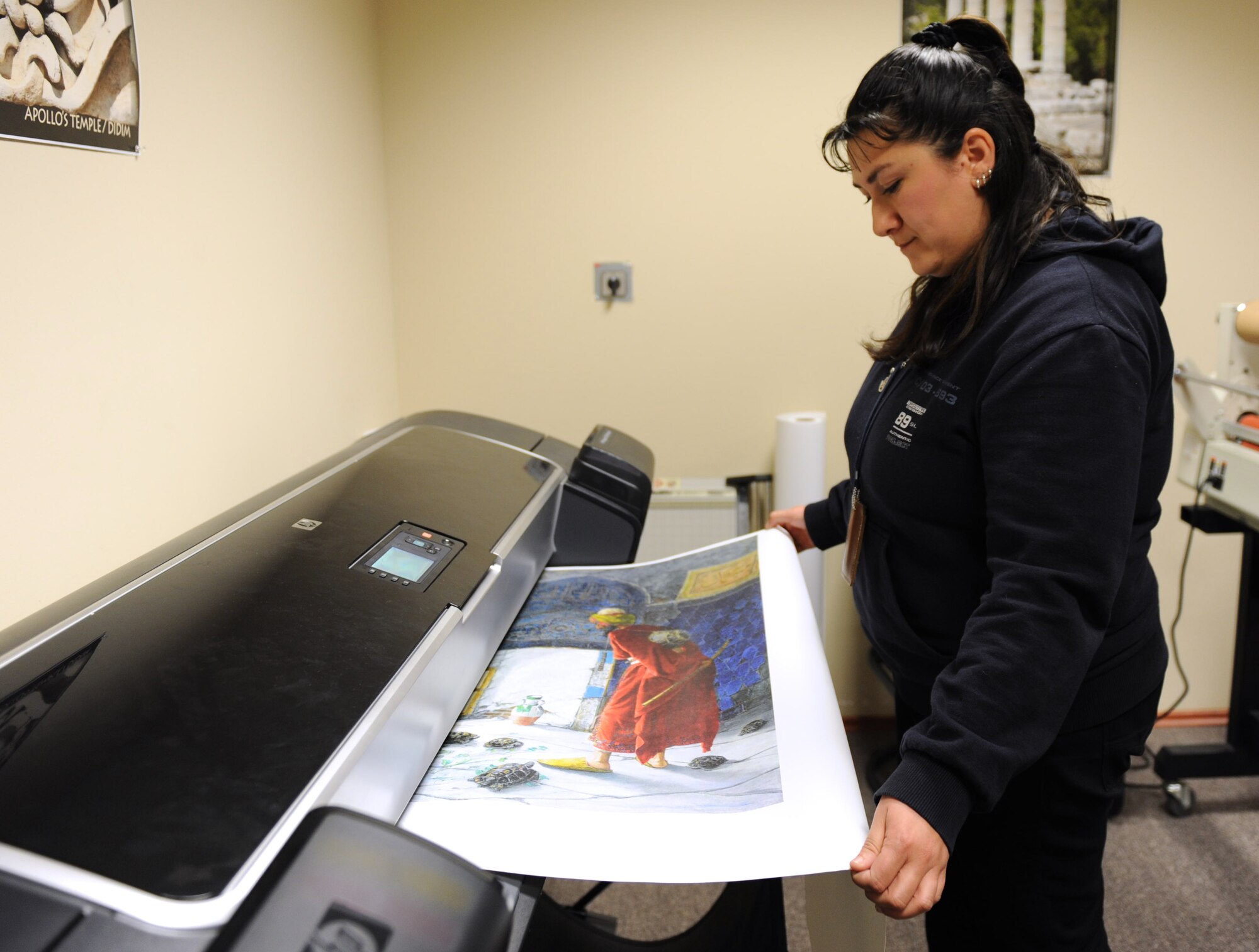 Fatma Yoksuloglu, 39th Force Support Squadron acting marketing director, prints a canvas poster Feb. 29, 2012, at Incirlik Air Base, Turkey. The marketing office creates and prints posters, pamphlets, and other showcase items for the Incirlik community. Marketing also runs the 39th FSS website, blog and Facebook page, sells advertising, and promotes base events. (U.S. Air Force photo by Senior Airman Anthony Sanchelli/Released)