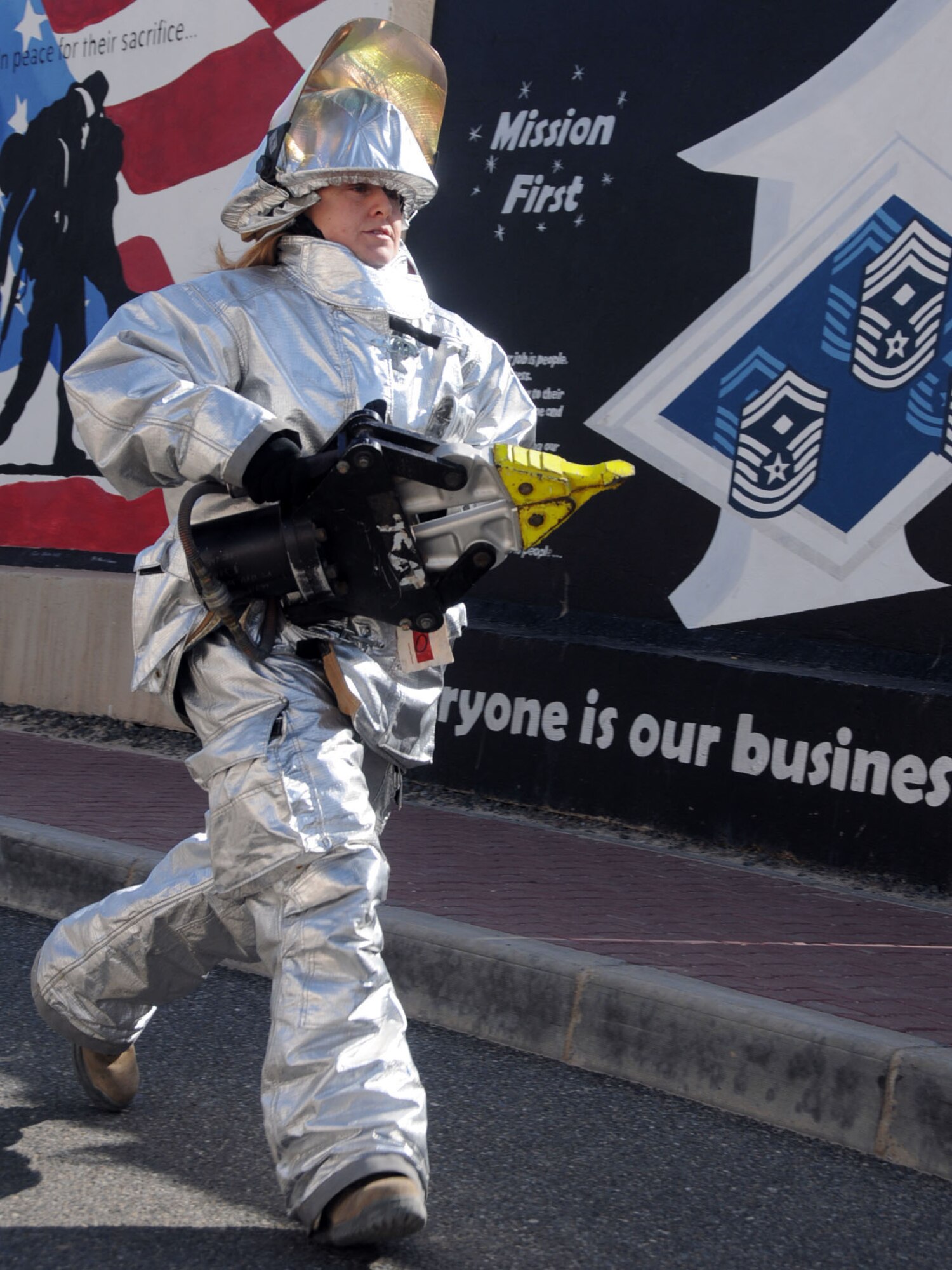 U.S. Air Force Staff Sgt. Alicia Binggeli, 386th Air Expeditionary Wing protocol member and native of Garland, Utah, carries a Hurst hydraulic tool during a Firefighters Combat Challenge at an undisclosed location in Southwest Asia, Feb. 26, 2012. Binggeli carried the tool approximately 25 meters at one of the six stations during the circuit in which she won first place for the best time of completion in the female category; the event was hosted by 386th ECES firefighters to support physical fitness and base morale. (U.S. Air Force photo by Staff Sgt. James Lieth/Released)
