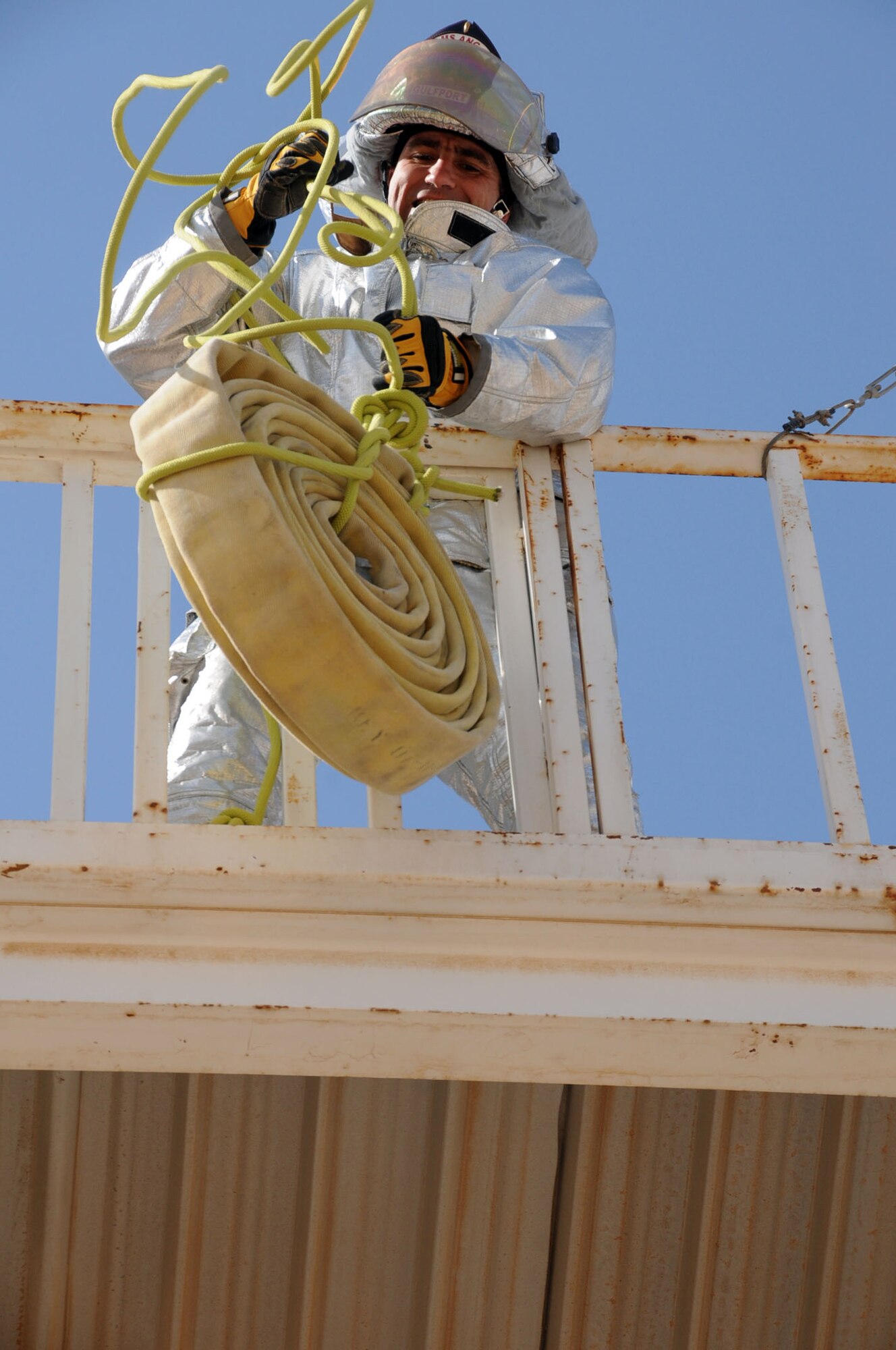 U.S. Air Force Lt. Col. Thomas Defazio, 386th Expeditionary Civil Engineering Squadron commander and native of DuBois, Pa., hoists a hose up a 3-story tower during a Firefighters Combat Challenge at an undisclosed location in Southwest Asia, Feb. 26, 2012.  Defazio hoisted the hose at one of the six stations during the circuit; the event was hosted by 386th ECES firefighters to support physical fitness and base morale. (U.S. Air Force photo by Staff Sgt. James Lieth/Released)