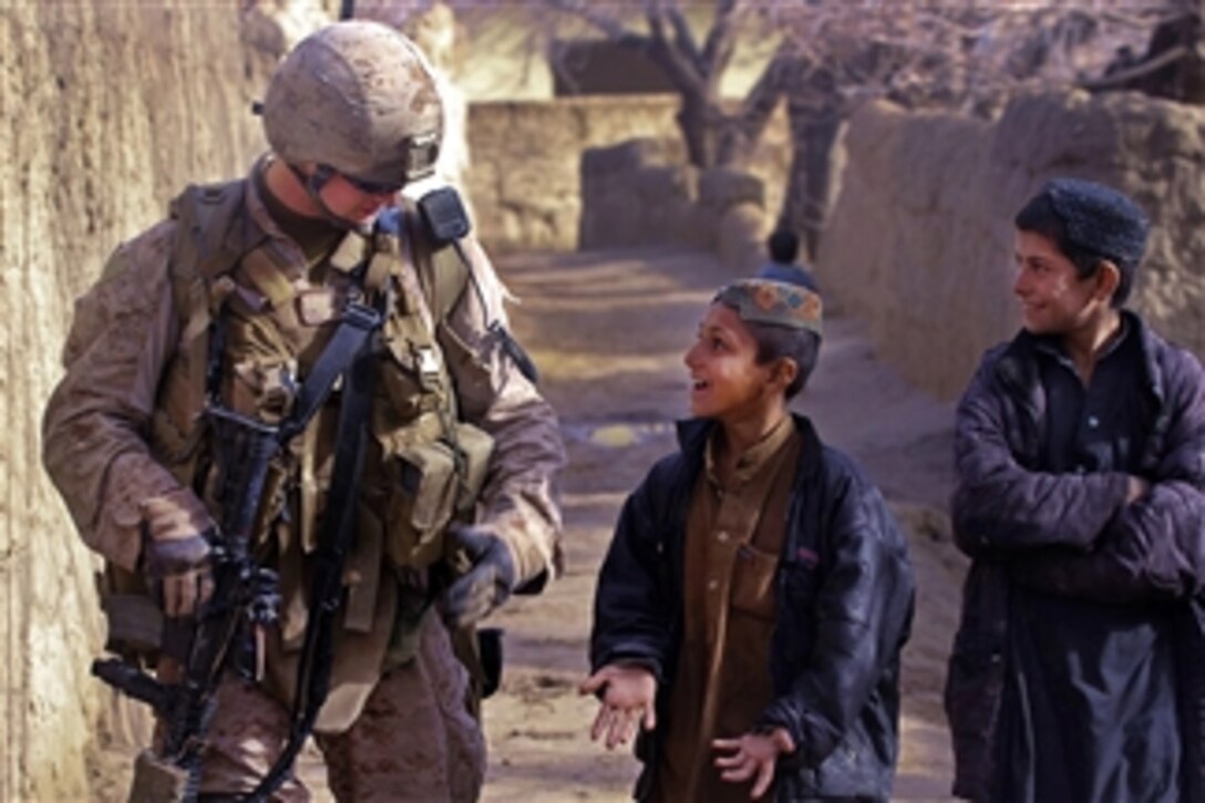 U.S. Marine Corps Cpl. Michael Greenleaf jokes with two Afghan boys during a patrol in Sangin in Afghanistan's Helmand province on Feb. 20, 2012.  Greenleaf is a radio operator assigned to India Company, 3rd Battalion, 7th Marine Regiment.  