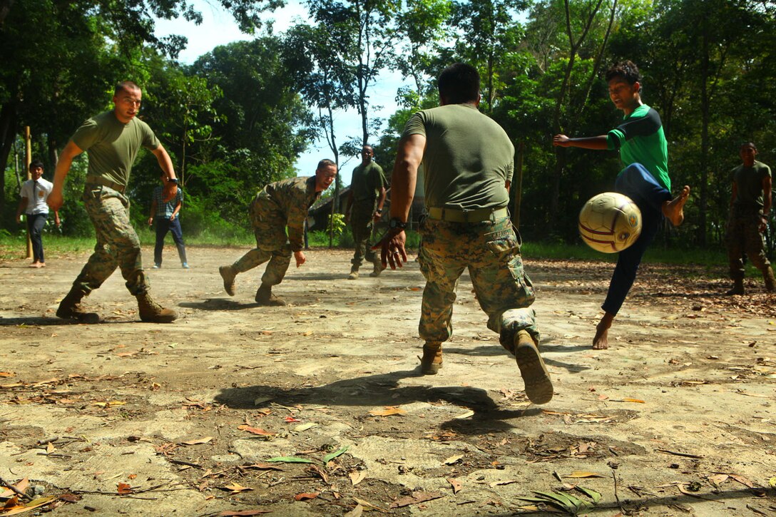 ANTRA LINA TRAINING AREA, Indonesia-An Indonesian child kicks a ball into the goal past Capt. Rudy Cazares, company commander with Landing Force Company. Marines with the company played a game of soccer with the children to build relationships with the surrounding community during a training pause. The Marines and Sailors, primarily from 2nd Battalion, 23rd Marine Regiment, are participating in Cooperation Afloat Readiness and Training (CARAT) 2011 through June. CARAT is an annual bilateral exercise held between the U.S. and Southeast Asian nations with the goals of enhancing regional cooperation, promoting mutual trust and understanding and increasing operational readiness throughout the participating nations. While in Indonesia, the service members from both nations trained in martial arts, military operations in urban terrain, jungle survival, combat marksmanship, sniper techniques and combat lifesaving skills.