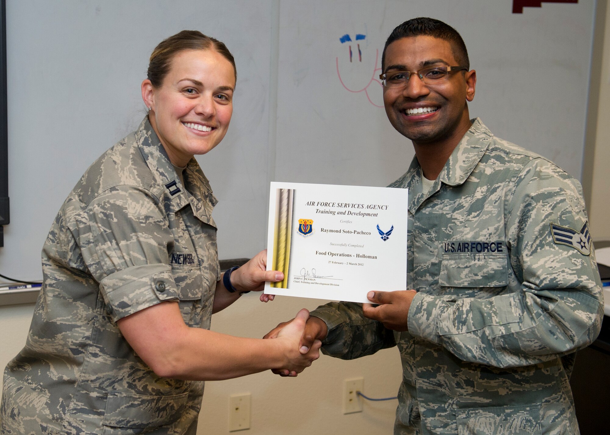 HOLLOMAN AIR FORCE BASE, N.M. – U.S. Air Force Capt. Laura Newberg, 49th Force Support Squadron sustainment flight commander, presents U.S. Air Force Senior Airman Raymond Soto-Pacheco, 49th Force Support Squadron dining facility shift leader, a certificate for completing additional training March 1. Sixteen Airmen participated in the training to refine their skills within various force support squadron career fields. (U.S. Air Force photo by Airman 1st Class Daniel E. Liddicoet/Released)