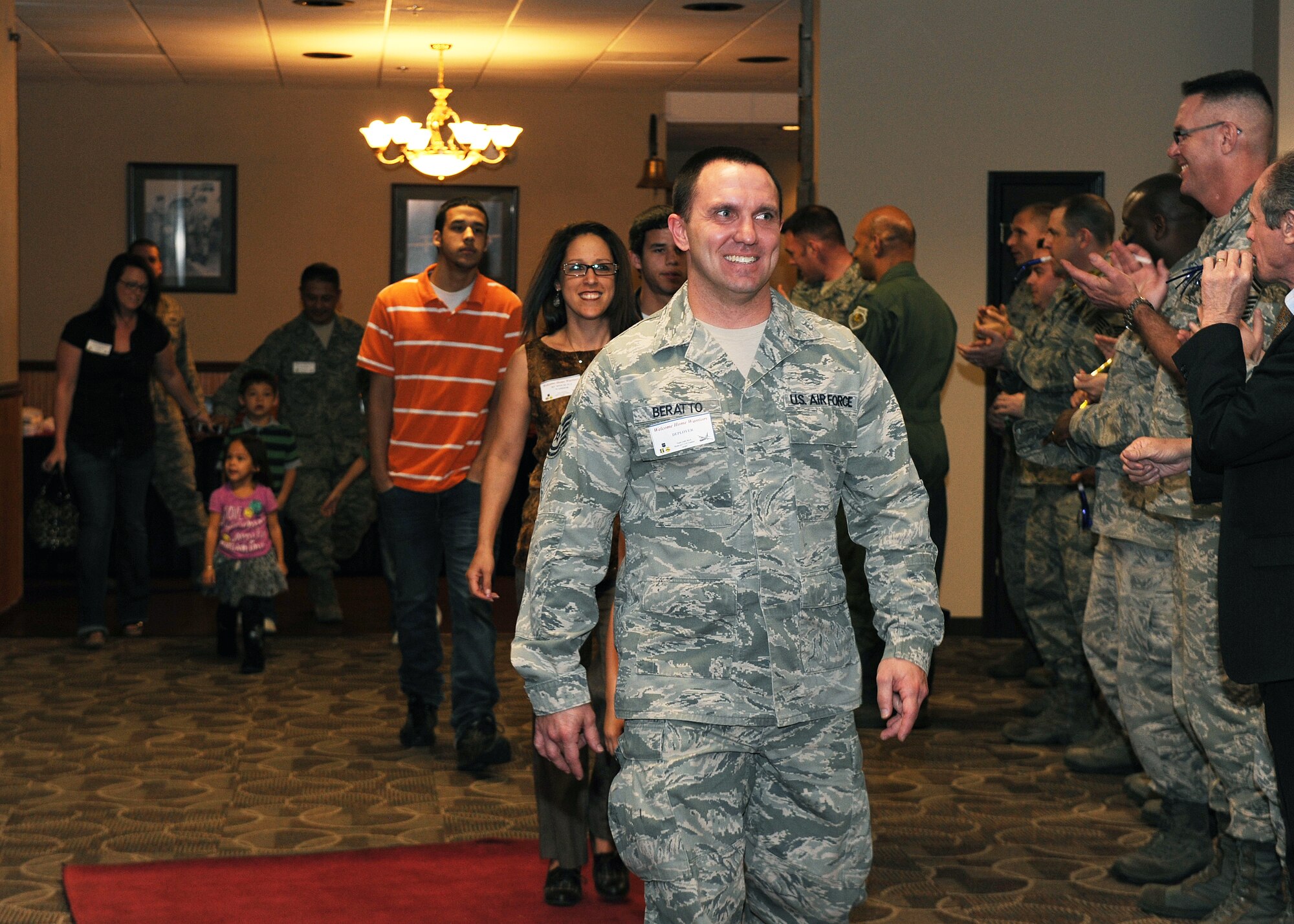 Team Little Rock members walk down the red carpet while being greeted by friends and family at the Welcome Home Warrior event on base, March 2, 2012, at Little Rock Air Force Base, Ark. The Welcome Home warrior’s event is designed to recognize deployers who returned home through in small groups, and not part of a large rotator. (U.S. Air Force photo by Airman 1st Class Ellora Remington)