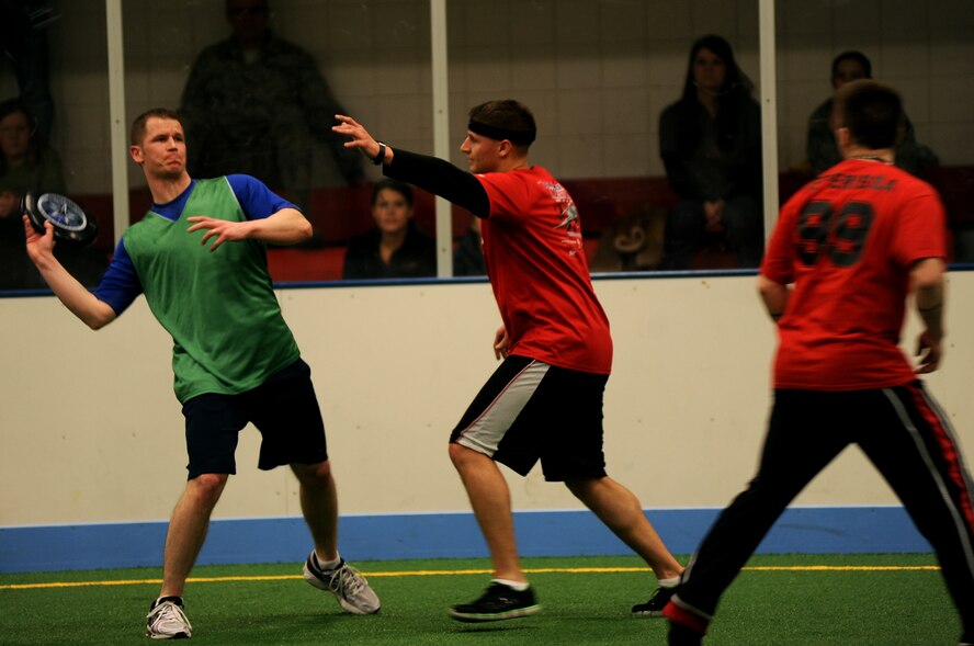 Staff Sgt. James Madnick, 319th Medical Group, throws the Frisbee as Senior Airman Shane Holland, 319th Civil Engineer Squadron, tries to block the pass during the Grand Forks Air Force Base, N.D., Ultimate Frisbee Championship game on March 1, 2012. The 319th Civil Engineer Squadron came out on top with their 5th consecutive championship game win. (U.S. Air Force photo by Staff Sgt. Amanda N. Grabiec)