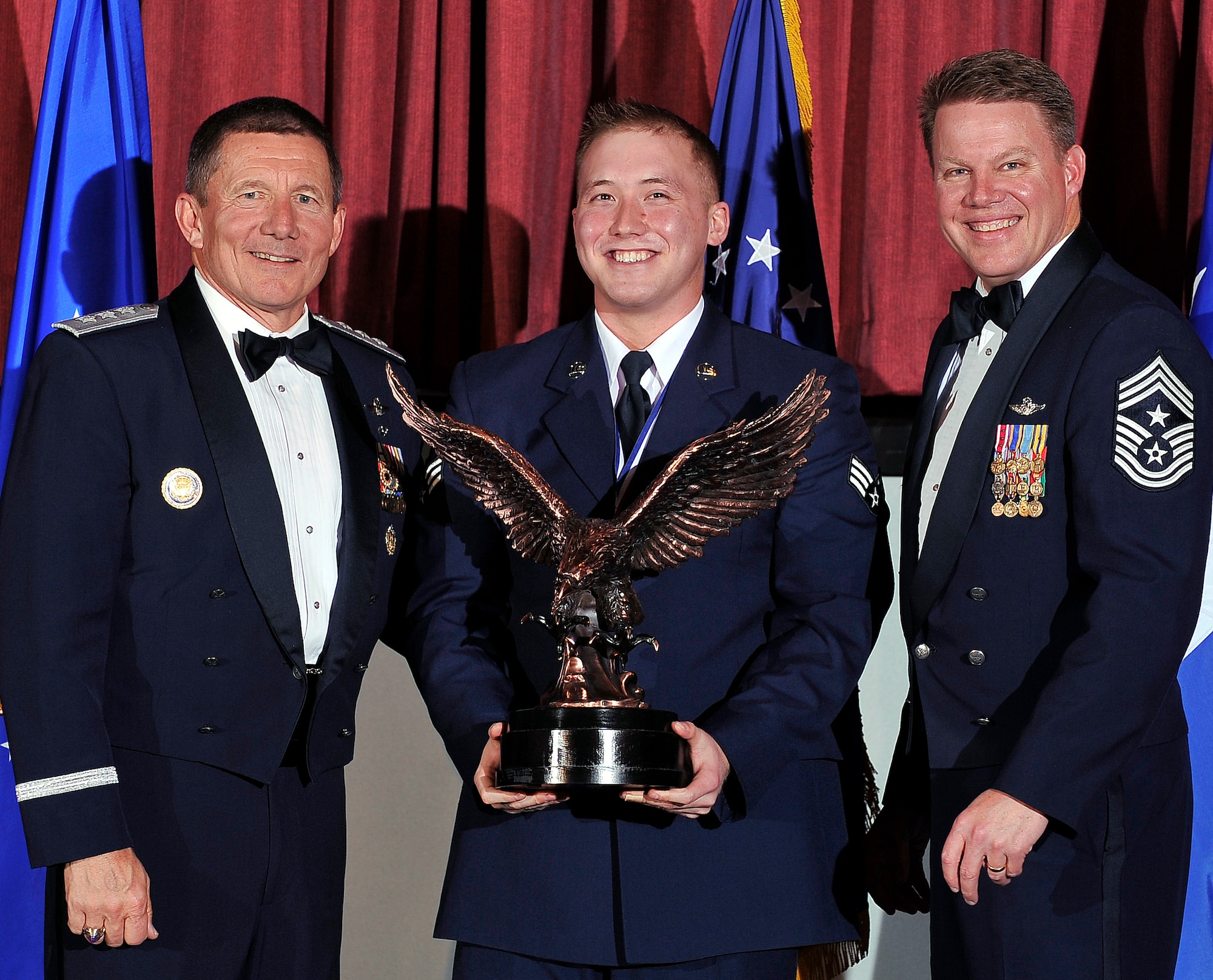 Air Force Academy Superintendent Lt. Gen. Mike Gould (left) and Chief Master Sgt. Todd Salzman, the Academy command chief (right) pose with the Academy’s Airman of the Year, Senior Airman Joseph McIlvaine, during the Academy Awards ceremony at the Falcon Club Feb. 25, 2012. McIlvaine is assigned to the 10th Surgical Operations Squadron. (U.S. Air Force photo/Elizabeth Andrews)