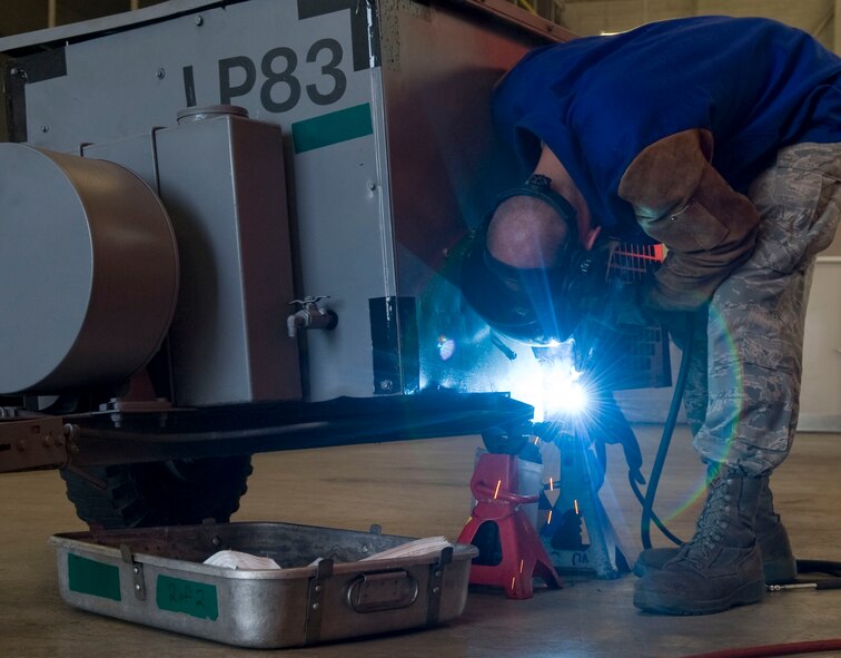 Airman 1st Class Jared Henden, 2nd Maintenance Squadron aircraft metal technologist, fixes an axle on the wheel of a low-pack air compressor on Barksdale Air Force Base, La., March 1. The 2 MXS aircraft metal Airmen usually make metal parts for aircraft and repair Aerospace Ground Equipment such as low-pack air compressors and B4 and B5 maintenance stands. (U.S. Air Force photo/Senior Airman Kristin High)(RELEASED)