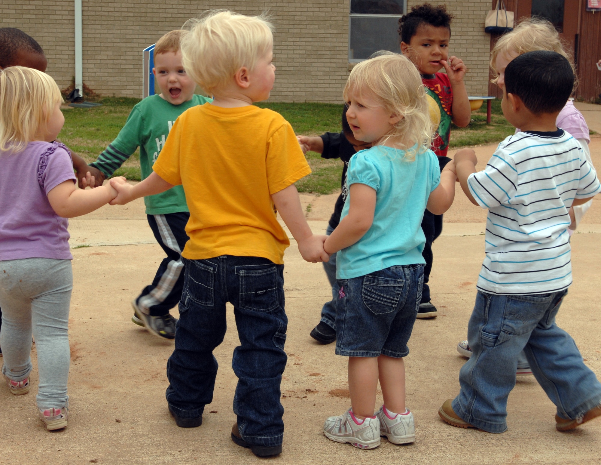 Children play outside of the Child Development Center on Barksdale Air Force Base, La., Feb. 29. The 1 and 2-year-olds often play games with the teachers during outside time. Exhausted, they return inside to have lunch and take a nap. (U.S. Air Force photo/Airman 1st Class Joseph A. Pagán Jr.)(RELEASED)