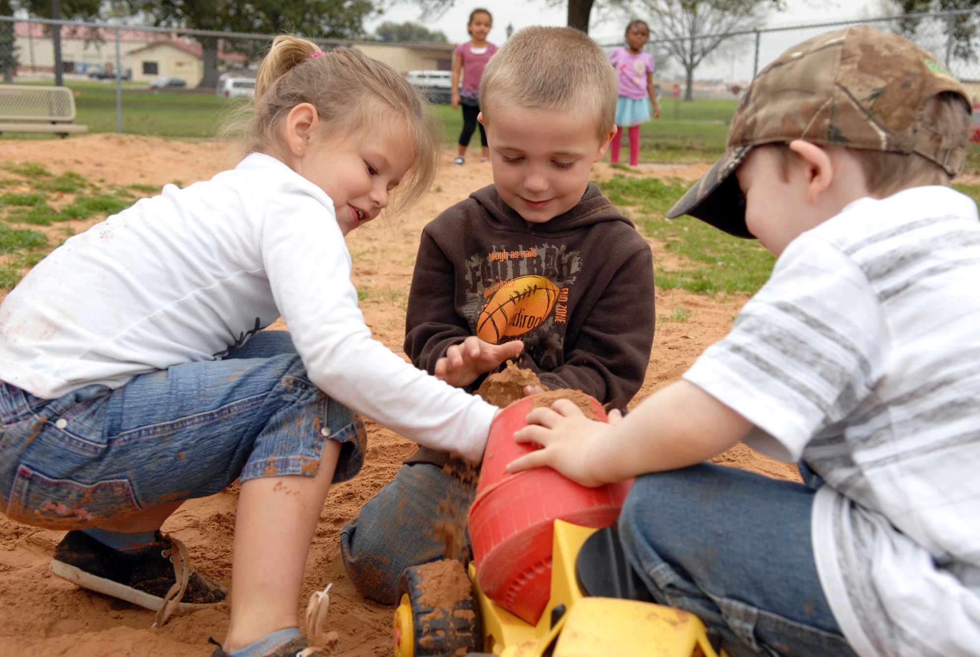 Children fill a toy truck with dirt at the Child Development Center on Barksdale Air Force Base, La., Feb. 29. Digging holes and playing in the dirt are some of the many activities the children can participate in while outside. (U.S. Air Force photo/Airman 1st Class Joseph A. Pagán Jr.)(RELEASED)