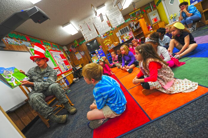 Senior Airman Maroun Arnaout reads "The Lorax" by Dr. Seuss to a kindergarten class at St. Andrews Elementary while wearing the classic red and white hat made famous by the Dr. Seuss character, Cat in the Hat. Arnaout is from the 437th Maintenance Squadron, 437th Airlift Wing. (U.S. Air Force Photo / Staff Sgt. Nicole Mickle)