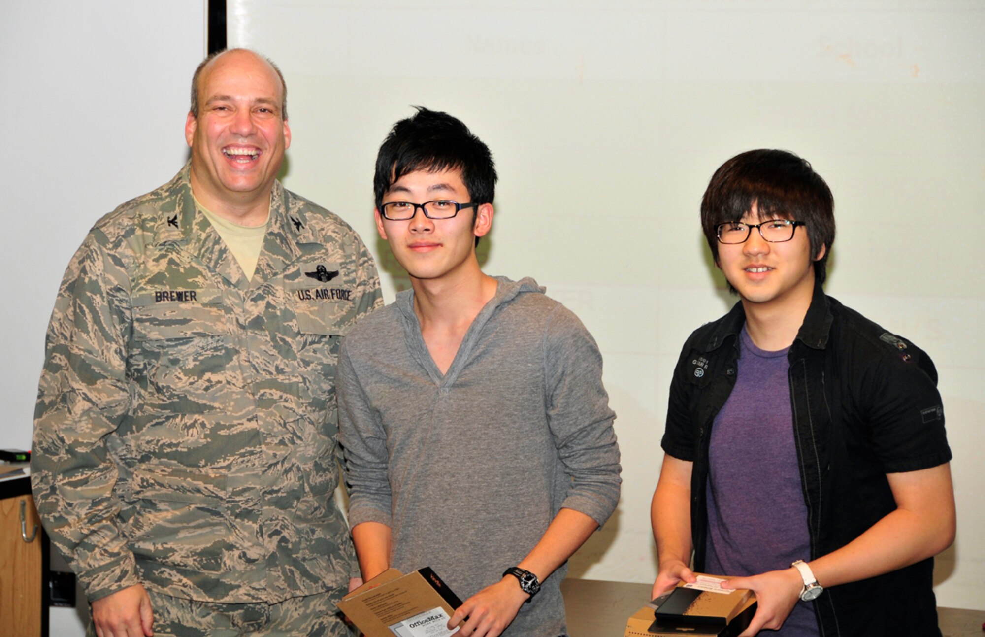 Webb School students Tianyuen Wang and Dongwan Choi pose with AEDC Commander Col. Michael Brewer after receiving second place in this year’s Student Design Competition. (Photo by Jacqueline Cowan)