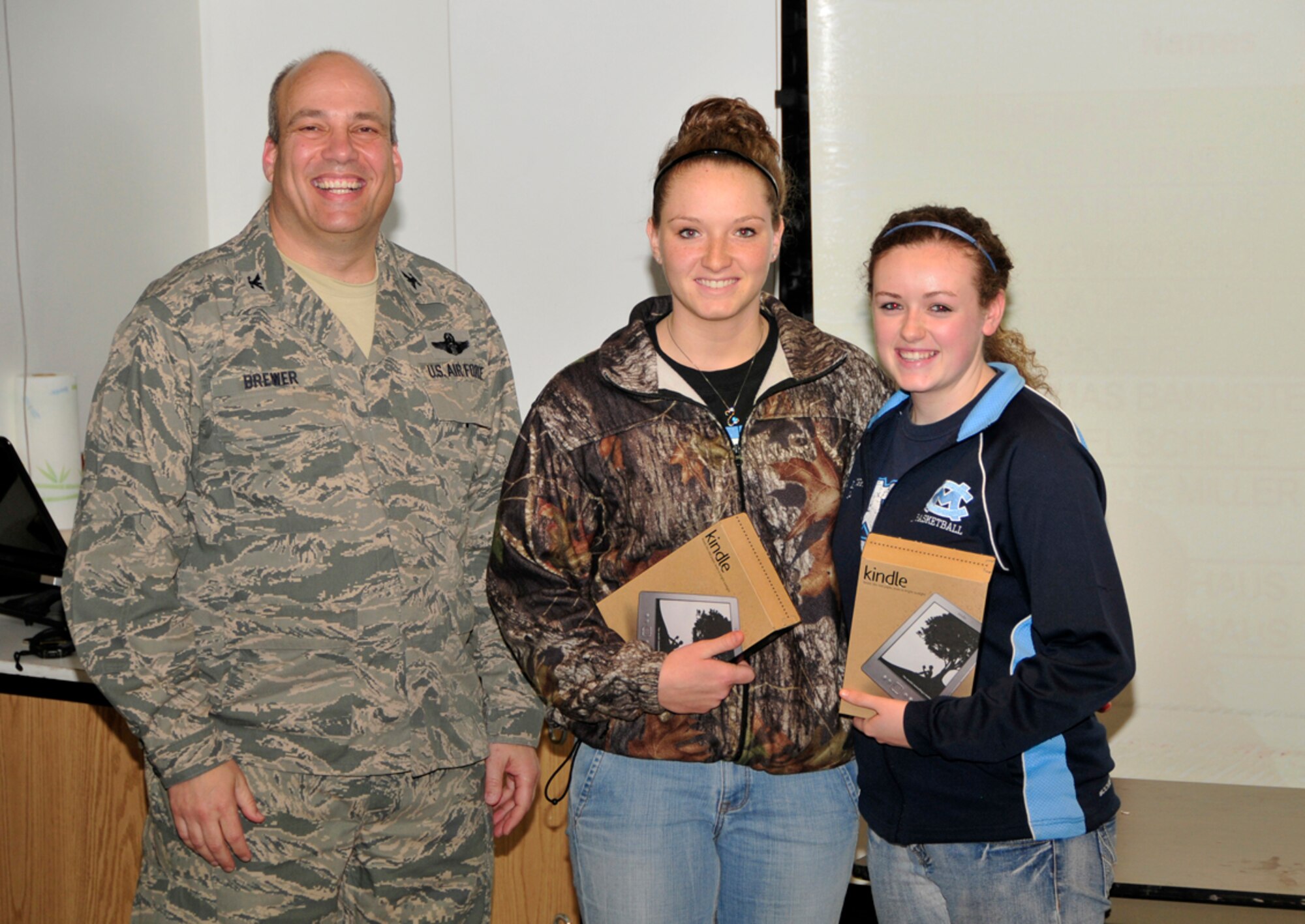 Moore County High School students Erica Limbaugh and Sarah Raby pose with AEDC Commander Col. Michael Brewer after receiving third place in this year’s Student Design Competition. (Photo by Jacqueline Cowan)
