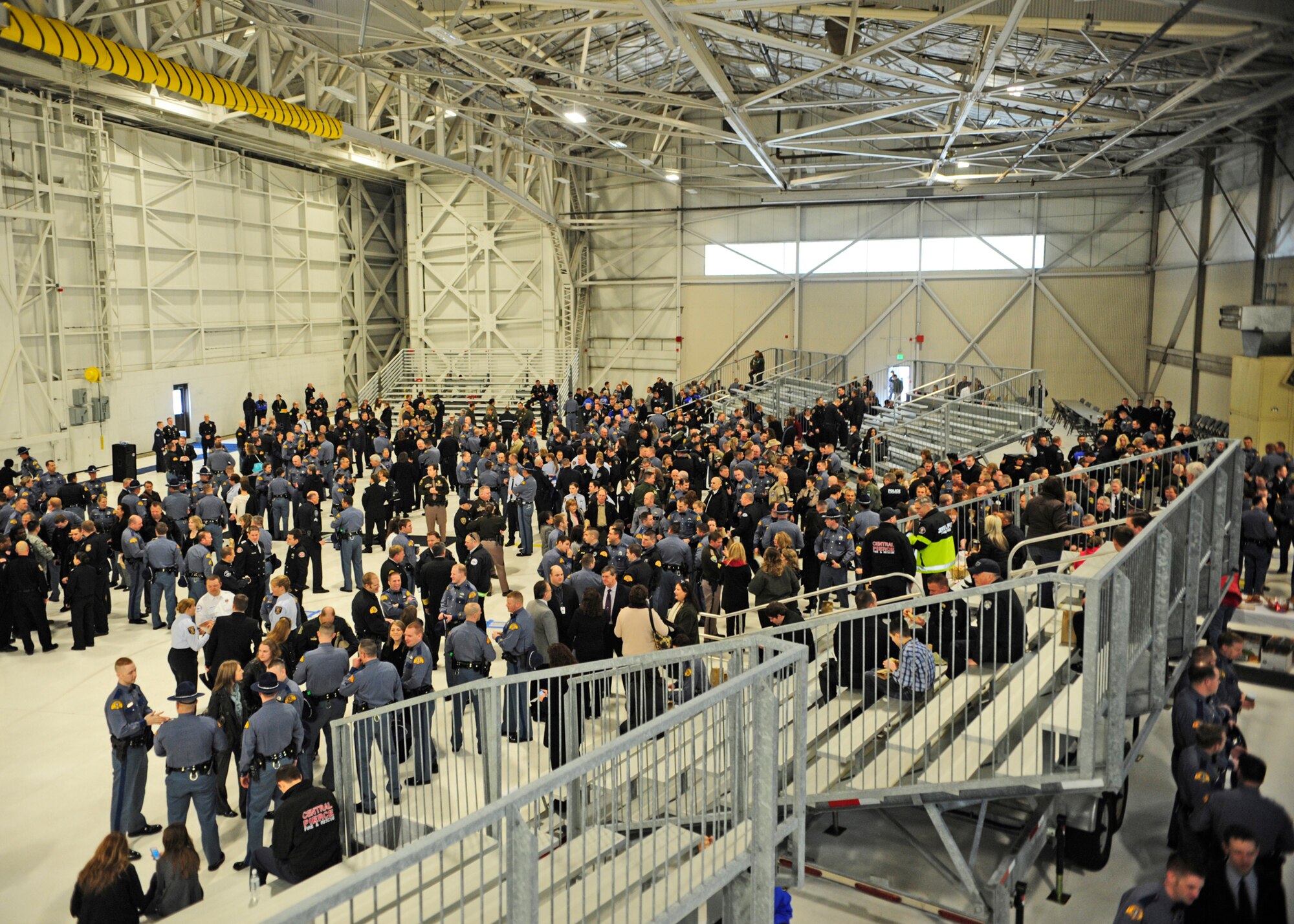Hundreds of law enforcement personnel from the surrounding community gathered March 1, 2012, at Joint Base Lewis-McChord, Wash., joining a procession to a memorial service for fallen Washington State Patrol Trooper Tony Radulescu, killed in the line of duty. One of the hangars on McChord Field was used to provide warmth prior to their departure. (U.S. Air Force photo/Airman 1st Class Leah Young)