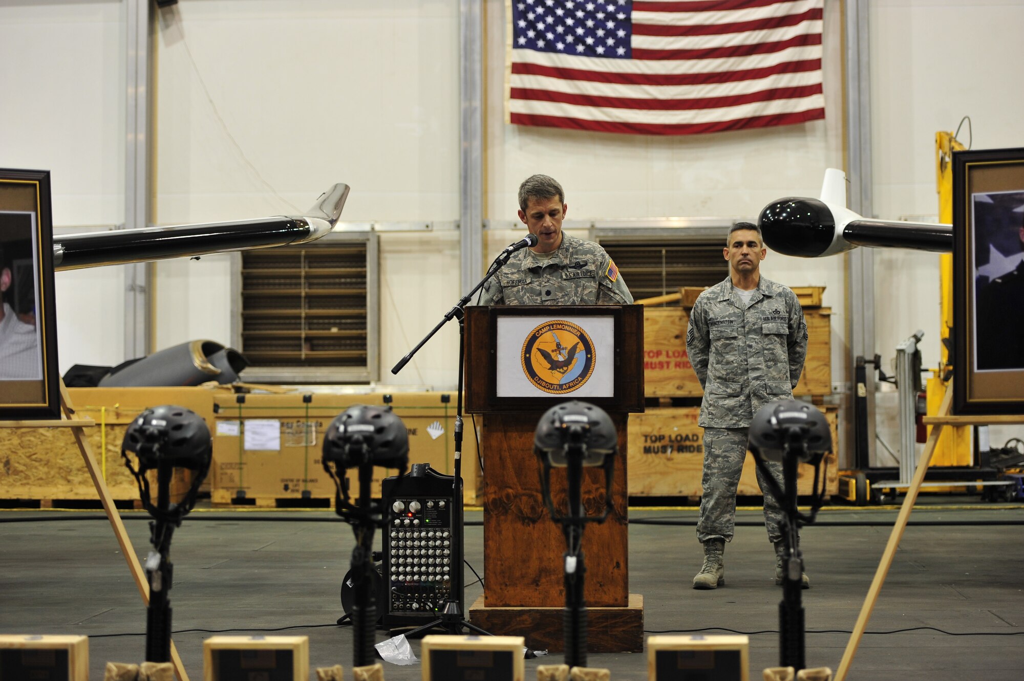 Lt. Col. Justin Hoffman, commander of the 34th Special Operations Squadron, speaks as Chief Master Sgt. Christopher Vondenstein, 1st Special Operations Support Squadron, looks on during a memorial service at Camp Lemonnier, Djibouti, Feb. 19, 2012. The memorial service honored the service and sacrifice made by Capt. Ryan P. Hall from the 319th Special Operations Squadron, Capt. Nicholas S. Whitlock and 1st Lt. Justin Wilkens from the 34th Special Operations Squadron and Senior Airman Julian S. Scholten from the 25th Intelligence Squadron who all died in a Feb. 18, 2012, U-28A crash in Djibouti, Africa. (U.S. Air Force photo/Staff Sgt. Stephen Linch)