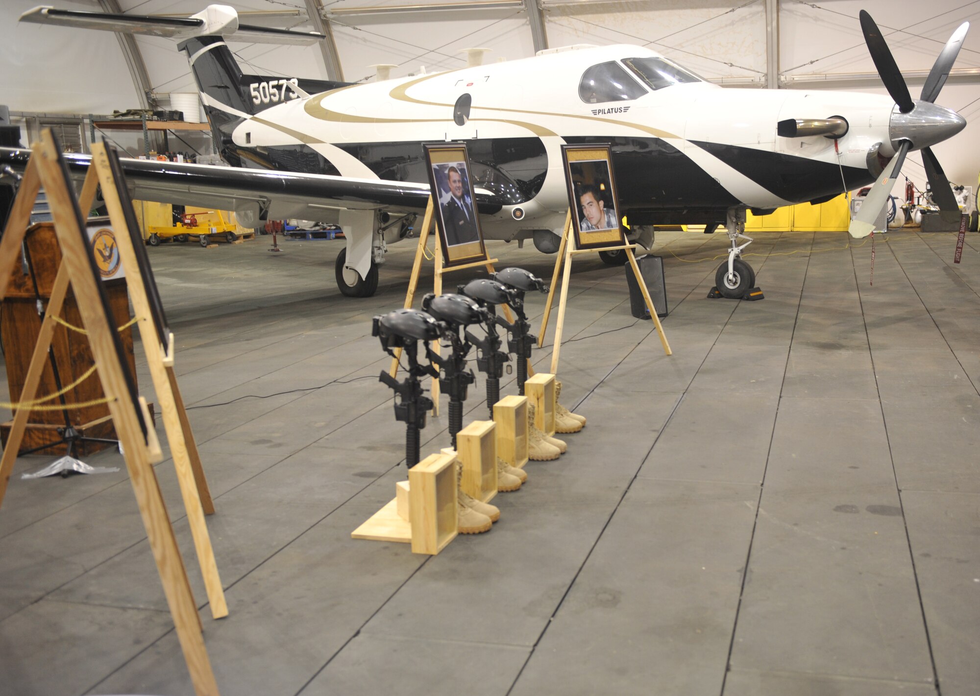 A U-28A is parked near four photo and tactical gear displays during a memorial service at Camp Lemonnier, Djibouti, Feb. 19, 2012. The memorial ceremony honored the lives of Capt. Ryan P. Hall from the 319th Special Operations Squadron, Capt. Nicholas S. Whitlock and 1st Lt. Justin J. Wilkens from the 34th Special Operations Squadron and Senior Airman Julian S. Scholten from the 25th Intelligence Squadron who all died in a Feb. 18, 2012, U-28A crash in Djibouti, Africa. (U.S. Air Force photo/Staff Sgt. Stephen Linch)