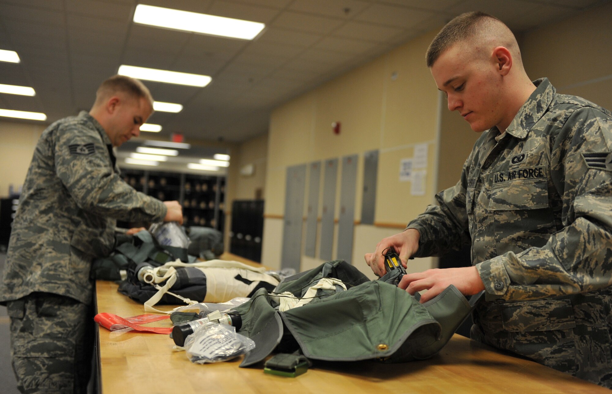 U.S.  Air Force Senior Airman Zachary Blankenship and Staff Sgt. Shawn Hubbard, 366th Operations Support Squadron aircrew flight equipment technicians, inspect the contents of kits that are placed under the seats of aircraft Feb. 27, 2012, at Mountain Home Air Force Base, Idaho. The kits contain an inflatable raft to help the aircrew survive if they have to unexpectedly evacuate the aircraft. (U.S. Air Force photo by Airman 1st Class Heather Hayward/Released)