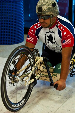Wesley Leon-Barrientos rides his hand-crank bike inside the Base Exchange March 1, 2012, at Nellis Air Force Base, Nev. Barrientos lost both of his legs while serving in Iraq as a U.S. Army infantryman. Leon-Barrientos and Staat embarked on this endeavor to raise awareness about veteran issues and build unity among American veterans. (U.S. Air Force photo by Senior Airman Brett Clashman)
