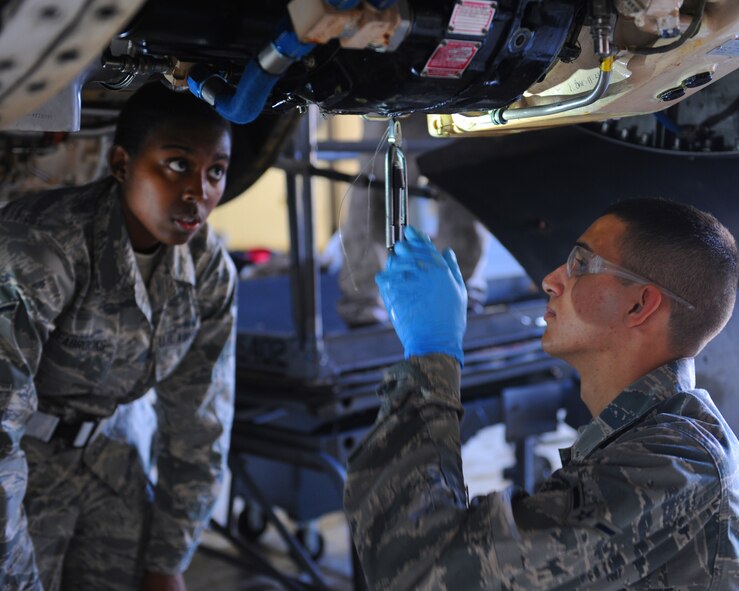 U.S. Air Force Airman Muriel Seabrooks, left, and Airman Giovanni Romano, right, work on a B-1 Bomber during crew chief training March 1, 2012, at Dyess Air Force Base, Texas. The students are working to achieve their journeyman skill level certification in their career field. (U.S. Air Force photo by Airman 1st Class Cierra Bullock/ Released)
