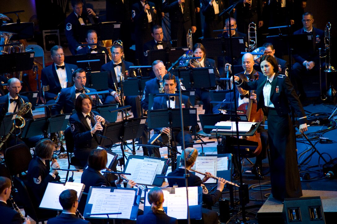 Second Lt. Shanti Nolan, United States Air Force Band conductor, guides USAF Band members through a song prior to Keiko Matsui, jazz pianist, taking center stage during the 47th Annual Guest Artist Series at Daughters of American Revolution Constitution Hall in Washington, D.C., on Feb. 26. (Photo/Bobby Jones)