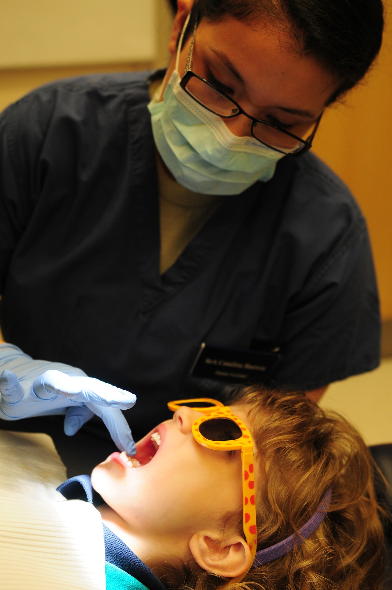 ROYAL AIR FORCE LAKENHEATH, England -- Senior Airman Catalina Barrow, 48th Dental Squadron dental assistant, applies vitamins to a patient's teeth after performing a routine cleaning, Feb. 28, 2012.  The 48 DS won the Air Force Large Dental Clinic for 2011 and is part of the 48th Medical Group, which recently won the Air Force Surgeon General's Best Hospital of the Year for the third year in a row. (U.S. Air Force photo by Senior Airman Lausanne Morgan)