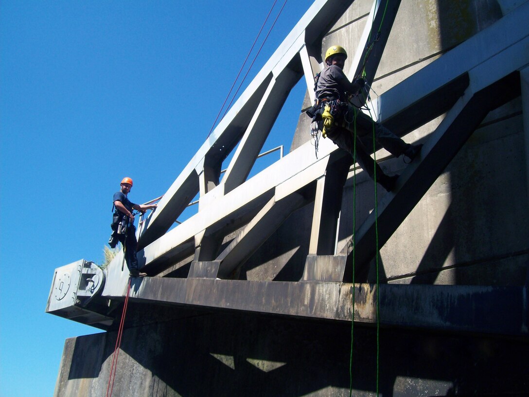 ILLLINOIS — Tom Ruf (right), structural engineer with the U.S. Army Corps of Engineers St. Louis District, inspects one of the four tainter gates on Carlyle Dam, Ill., in August 2011. To the left is Ropeworks technician Blake Dieste.