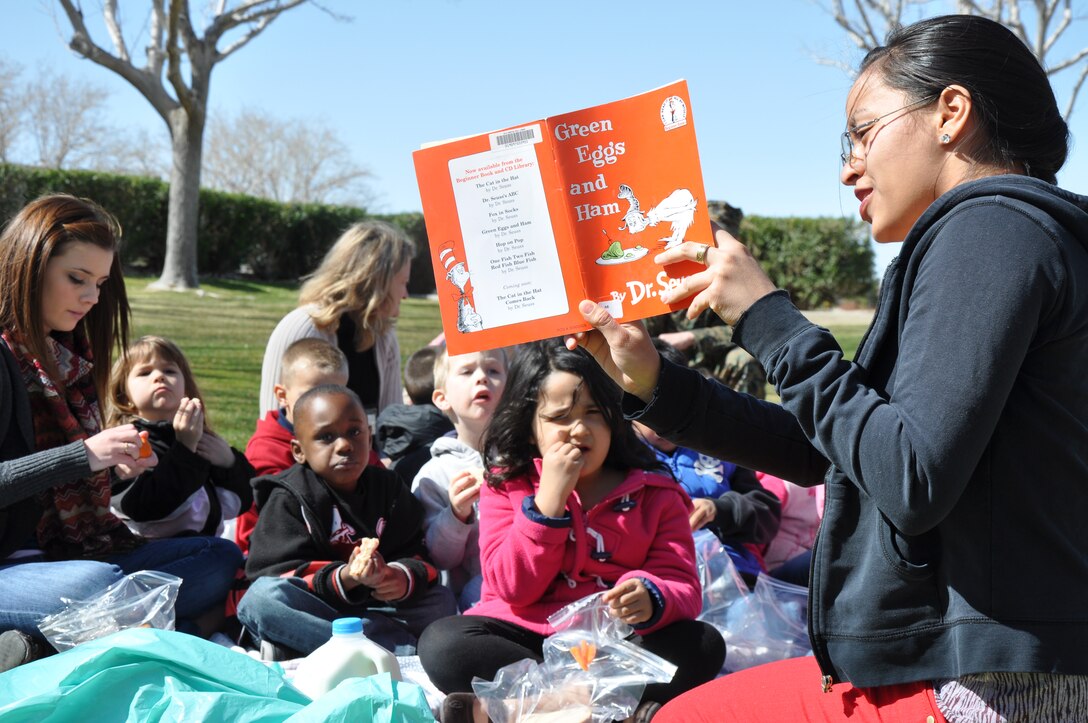 Taimane Mejia, a volunteer at McTureous Hall aboard Marine Corps Logistics Base Barstow, reads to children from the Child Development Center for the annual Dr. Seuss Birthday Bash March 2. During the event, children had stories read to them to help stress the importance of literacy at all ages and participated in other activites such as coloring and games.
