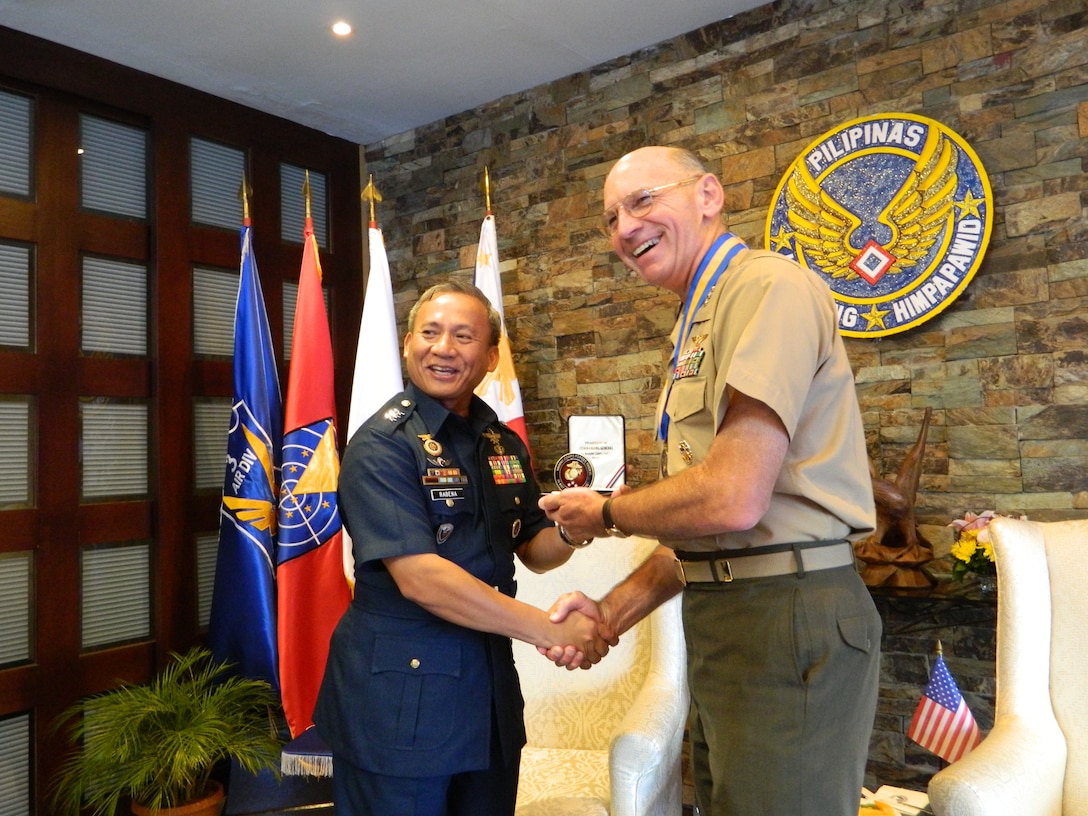 VILLAMOR AIR BASE, Philippines-Lt. Gen. Duane D. Thiessen, right, commander of U.S. Marine Corps Forces, Pacific, presents a Marine Corps challenge coin to Maj. Gen. Oscar Rabena, commanding general of the Philippine Air Force, during a visit to the PHAF headquarters at Villamor Air Base, Sept. 15. Thiessen visited the Philippines to meet with the U.S. ambassador, U.S. and Filipino military officials, and component commanders from the Armed Forces of the Philippines.                               