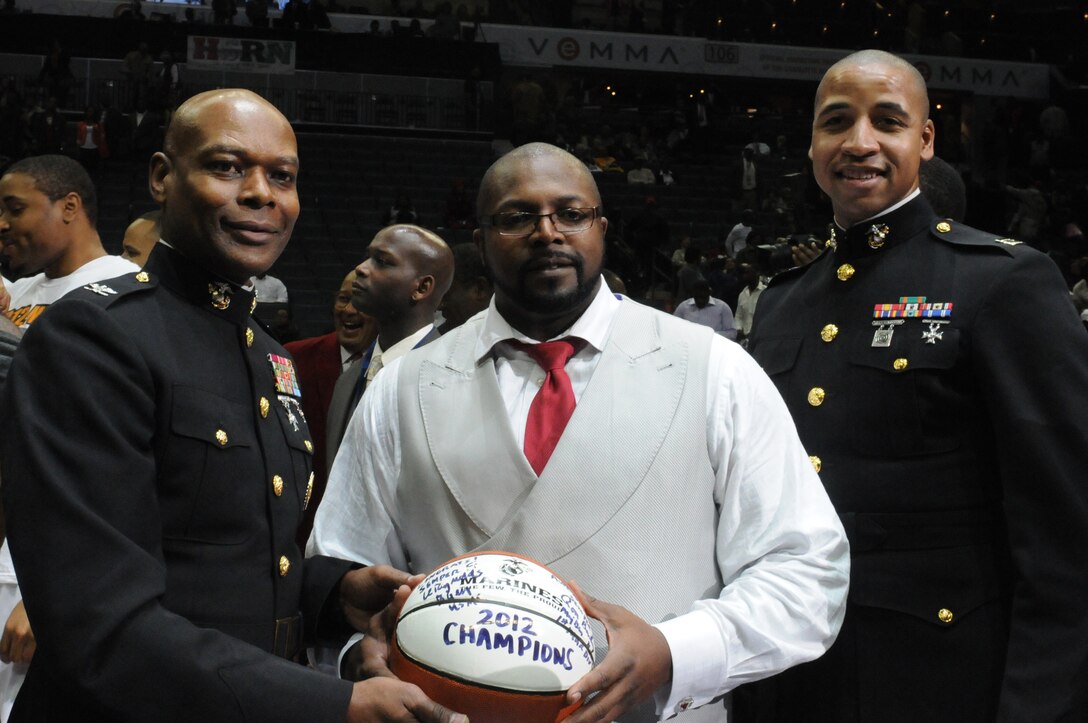Colonel Grover C. Lewis III (left), assistant chief of staff/ director of the department of public safety, Marine Corps Installations East and Capt. Robert Brooks (right), officer selection officer for Gainesville, Fla., present Bobby Collins, head coach of Winston-Salem State University with a congratulatory basketball after his team won the 2012 Central Intercollegiate Athletic Conference (CIAA) basketball tournament, Charlotte, N.C., March 3, 2012. The CIAA tournament is the nation’s longest running historically black basketball tournament. (U.S. Marine Corps photo by Sgt. Michael V. Walters) (Released)