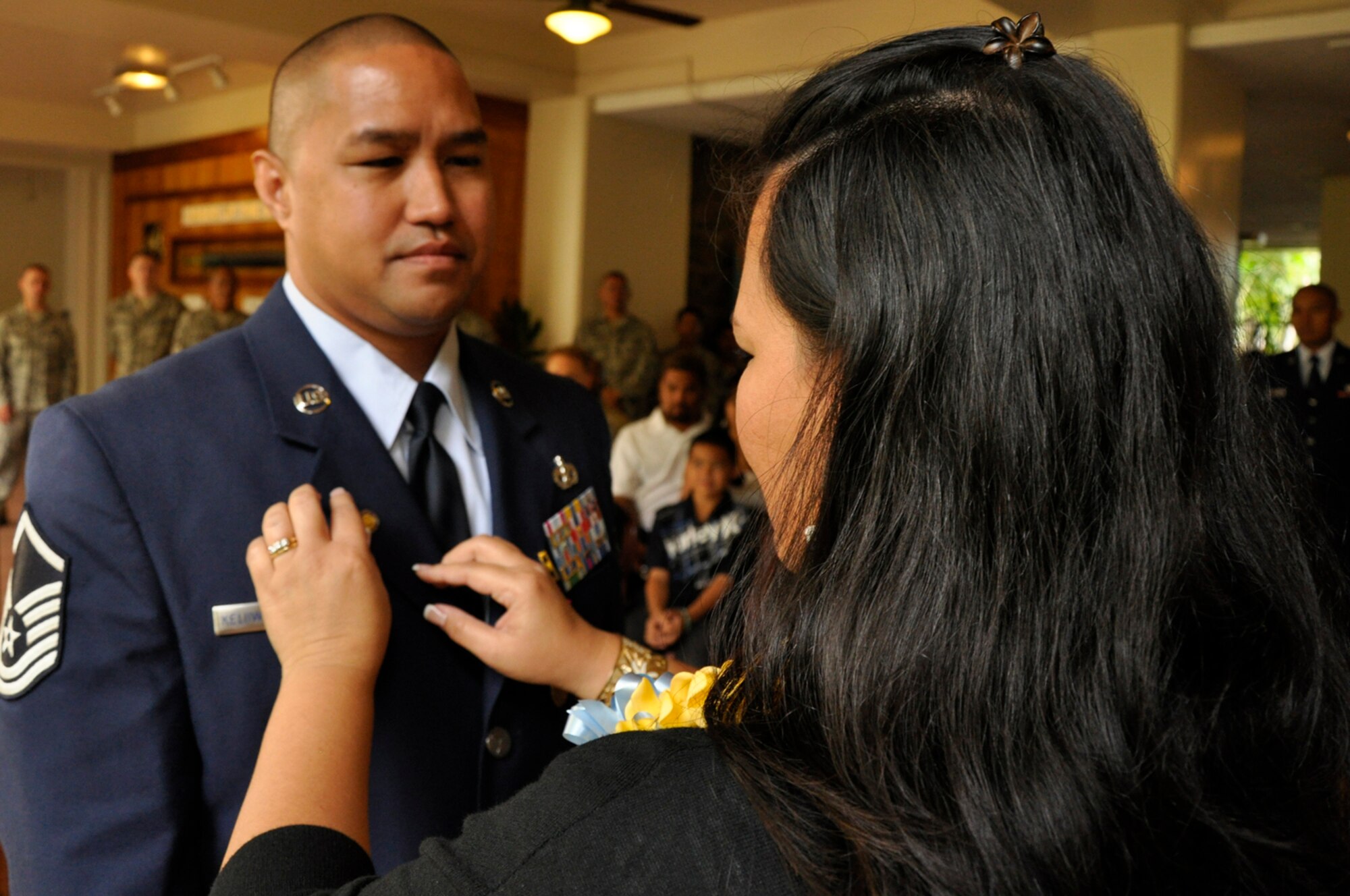 JOINT BASE PEARL HARBOR-HICKAM, Hawaii -- Master Sgt. Homer Keliiwaiwaiole watches as his wife Michelle places a retirement pin on his uniform lapel at a ceremony held in his honor March 3, 2012, at the Courtyard of Heroes at the Headquarters, Pacific Air Forces building here. Sergeant Keliiwaiwaiole retires from the Air Force Reserve after twenty-one years of service. He began life his career as an Air Transportation Specialist with the 48th Aerial Port Squadron in 1992. In 1995 he transferred to what is now known as the 624th Civil Engineer Squadron as a Liquid Fuel System Maintenance Specialist.  During his tenure, Sergeant Keliiwaiwaiole supported military Operations such as “Southern Watch,” “Noble Eagle,” “Cobra Gold,” “Iraqi Freedom,” and “Enduring Freedom.” (U.S. Air Force photo/Master Sgt. Daniel Nathaniel)