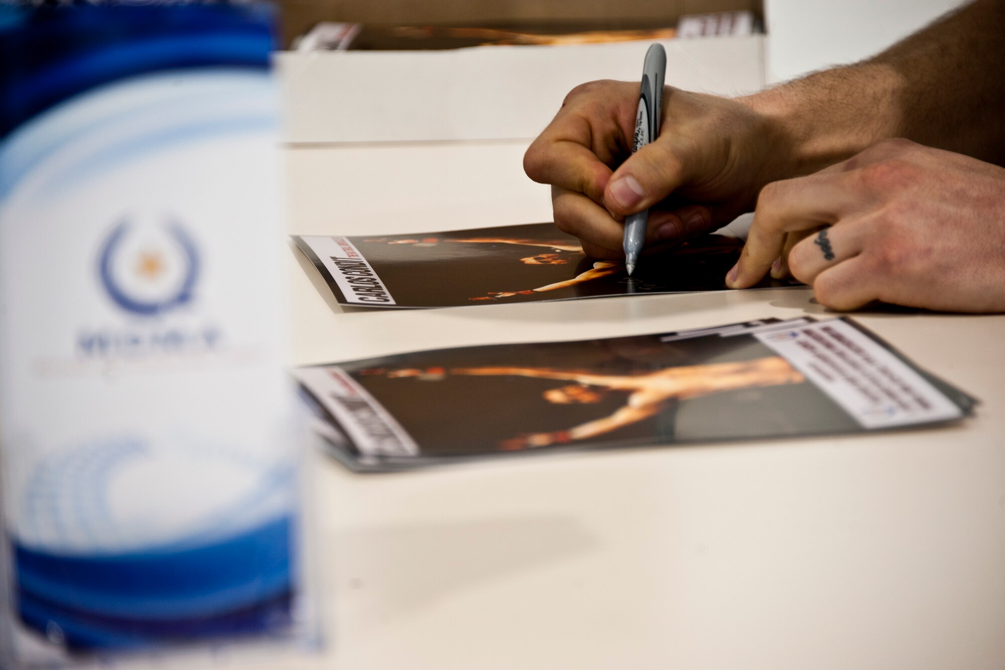 Carlos Condit, the Ultimate Fighting Championship interim welterweight champ, signs an autograph at the Marine Fighter Attack Squadron 501 March 2 at Eglin Air Force Base, Fla.  Condit visited and signed autographs at the 33rd Fighter Wing and 96th Air Base Wing.  (U.S. Air Force photo/Samuel King Jr.)