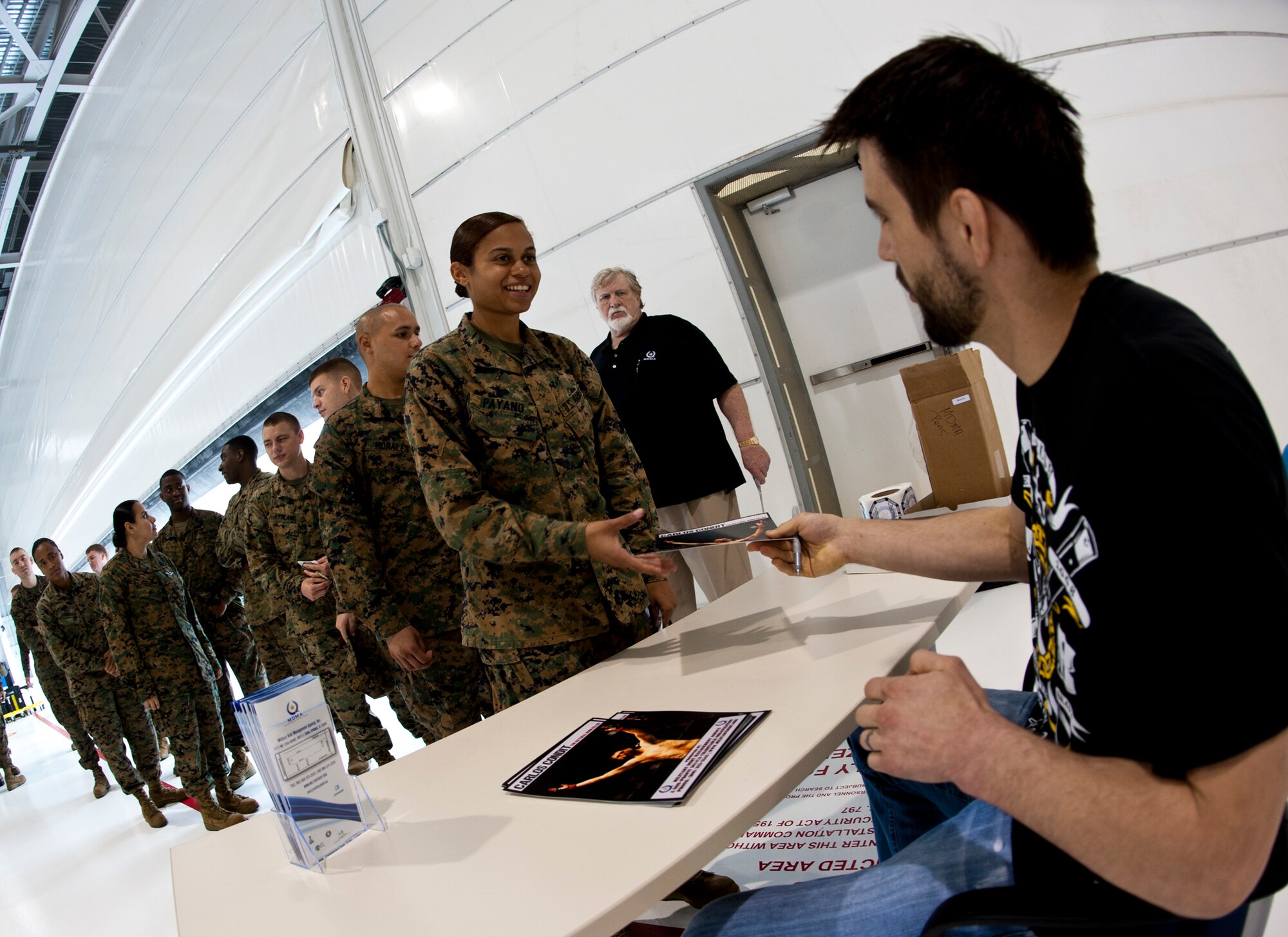 Carlos Condit, the Ultimate Fighting Championship interim welterweight champ, signs an autograph at the Marine Fighter Attack Squadron 501 March 2 at Eglin Air Force Base, Fla.  Condit visited and signed autographs at the 33rd Fighter Wing and 96th Air Base Wing.  (U.S. Air Force photo/Samuel King Jr.)