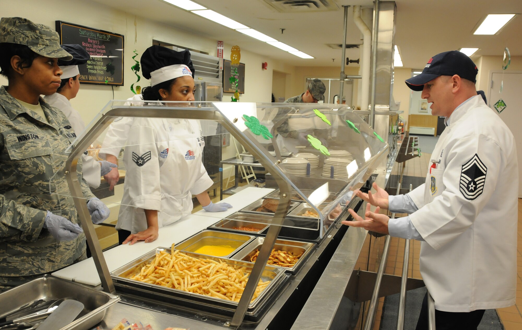 Hennessy inspector Senior Master Sgt. Brian J. Denny gives information to Senior Airman Dacine S. Robinson and Airmen 1st Class Camille Winston in the dining facility at Minneapolis-St. Paul Air Reserve Station, Minn. (U.S. Air Force Photo/Tech. Sgt. Bob Sommer)