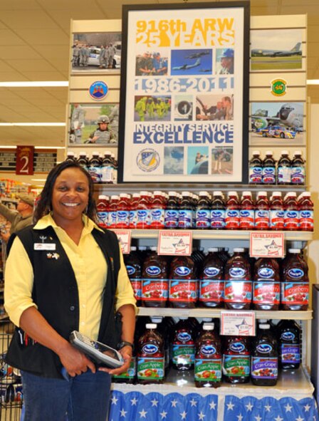 Pernell Harville, a commissary employee here, stands next to the end-cap display featuring the 916th Air Refueling Wing. (USAF photo by Staff Sgt. Mark Thompson, 916ARW/PA)