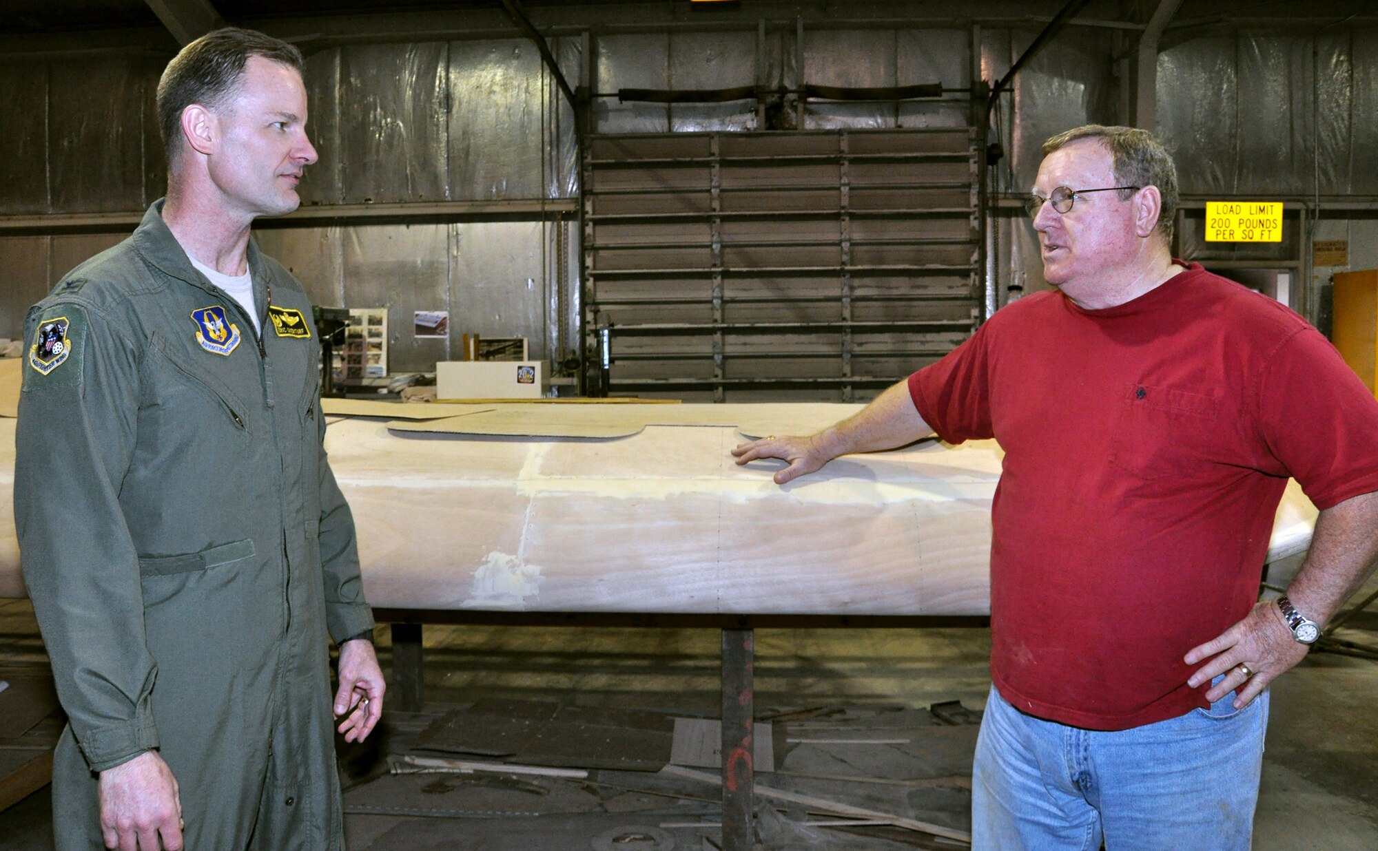 Brig. Gen. (then Col.) Eric Overturf, 442nd Fighter Wing Commander, speaks with Frank McKinley next to the wing of a CG-4A glider that is being restored by volunteers at Whiteman Air Force Base, Mo., Feb. 28. The 442nd Fighter Wing is an A-10 Thunderbolt II Air Force Reserve unit at Whiteman. (U.S. Air Force photo/Senior Airman Wesley Wright)