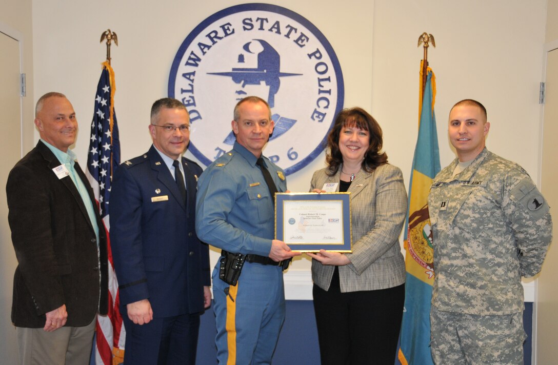 Judy Zaal, with the Delaware Employer Support of the Guard and Reserve, presents Col. Robert Coupe, Delaware State Police superintendent, with a Patriot Award March 2 at Delware State Police Troop 6. Delaware Army National Guard Capt. Daniel DeFlaviis (right) is a Delaware State Trooper who nominated Coupe for the award for being a being supportive employer of Guard and Reserve members. DeFlaviis serves with Delaware?s 72nd Troop Command. Frank B. Ingraham, Jr., Delaware ESGR chair, and Col. Randal L. Bright, 512th Airlift Wing commander, attended the award presentation. Both Coupe and Zaal are part of the Dover Air Force Base honorary commander program. Coupe served as Bright?s honorary commander from 2010 to 2011 and Zaal is Bright?s honorary commander this year. (U.S. Air Force photo by Capt. Marnee A.C. Losurdo) 