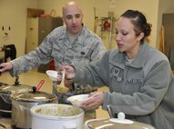 PETERSON AIR FORCE BASE, Colo., - Tech. Sgt. Aaron Thomas, 302nd Security Forces, eyeballs Tech. Sgt. Jessica James, 302nd Force Support Squadron, as she samples chili during the 302nd Airlift Wing Family Day Committee chili cook off  contest. The 302nd AW Family Day Committee’s annual chili cook off, held here March 1, included 18 entries of varying degrees of spice. Senior Airman Christopher Meyer, 39th Aerial Port Squadron took first place in the red chili category and Senior Master Sgt. Dean “Dino” Firestien, 39th Aerial Port Squadron took home the honors of first place in the green category. (U.S. Air Force Photo/Tech Sgt. Peter Dean)