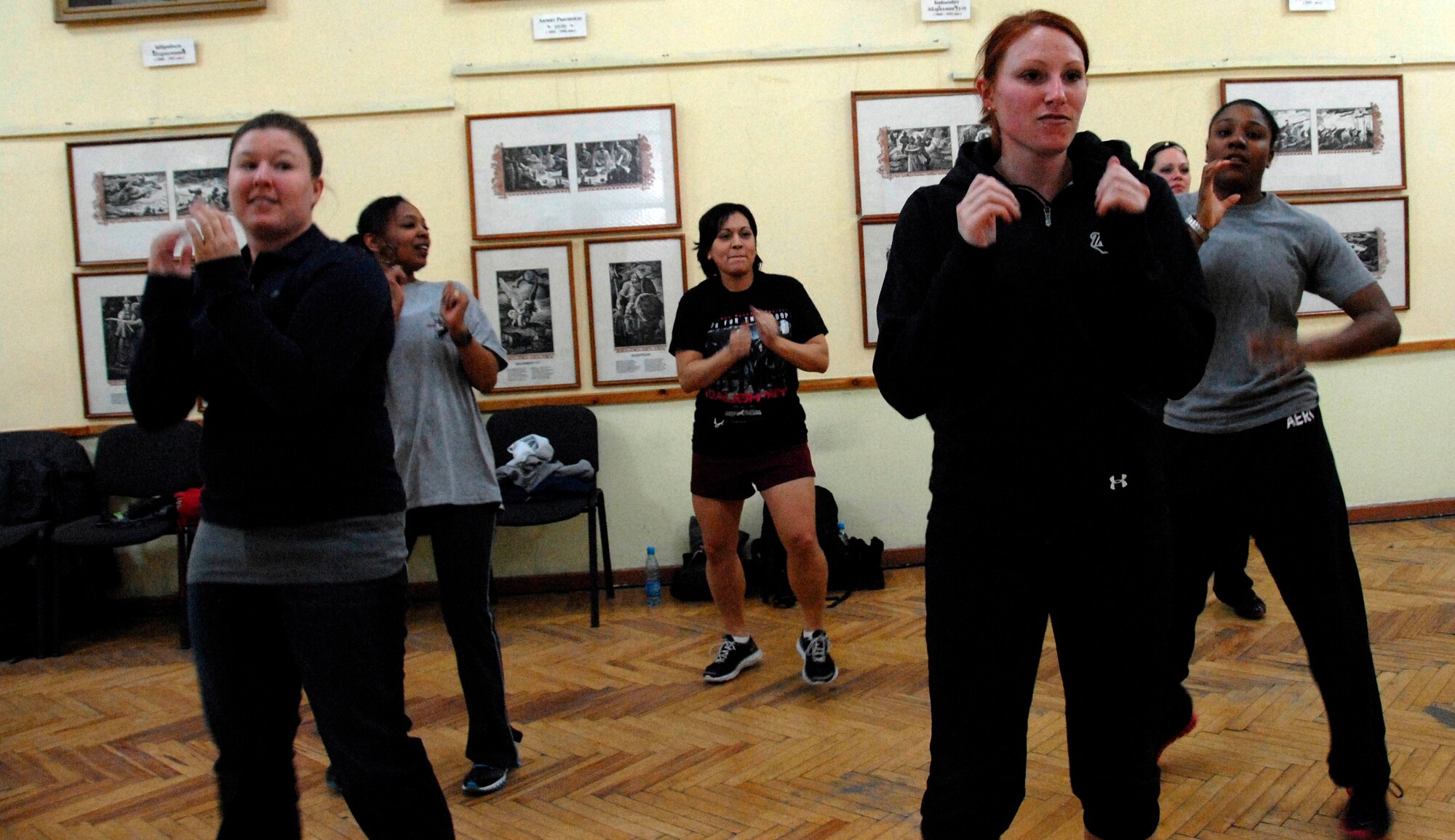 Transit Center Airmen warm up before a Zumba demonstration at the Bayalinov Children's Library in Bishkek, March 2, 2012, as part of the weekly Women's Club meeting. The group meets at the library to discuss a wide range of topics including this week's focus of fitness and exercise. (U.S. Air Force photo/Senior Airman Lynsie Nichols)