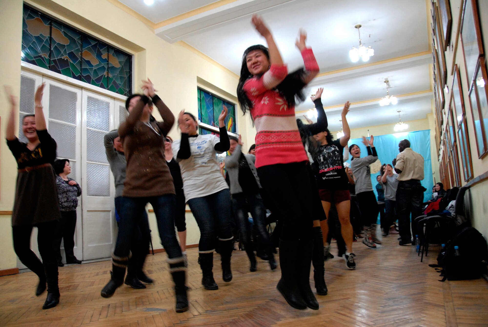 Kyrgyz girls and Transit Center Airmen dance together during a Zumba demonstration at Bayalinov Children's Library in Bishkek March 2, 2012. The group participated together as part of the weekly Women's Club. This week's topic was fitness and exercise. (U.S. Air Force photo/Senior Airman Lynsie Nichols)