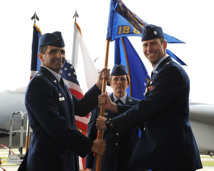 U.S. Air Force Col. David Nahom, 18th Operations Group commander, takes the squadron flag from Lt. Col. David Mineau, the relinquishing 18th Operations Support Squadron commander, during the 18th OSS change of command ceremony on Kadena Air Base, Japan, March 2, 2012. The present-day ceremony is primarily symbolic; it represents the passing of authority from the outgoing commander to the incoming commander.