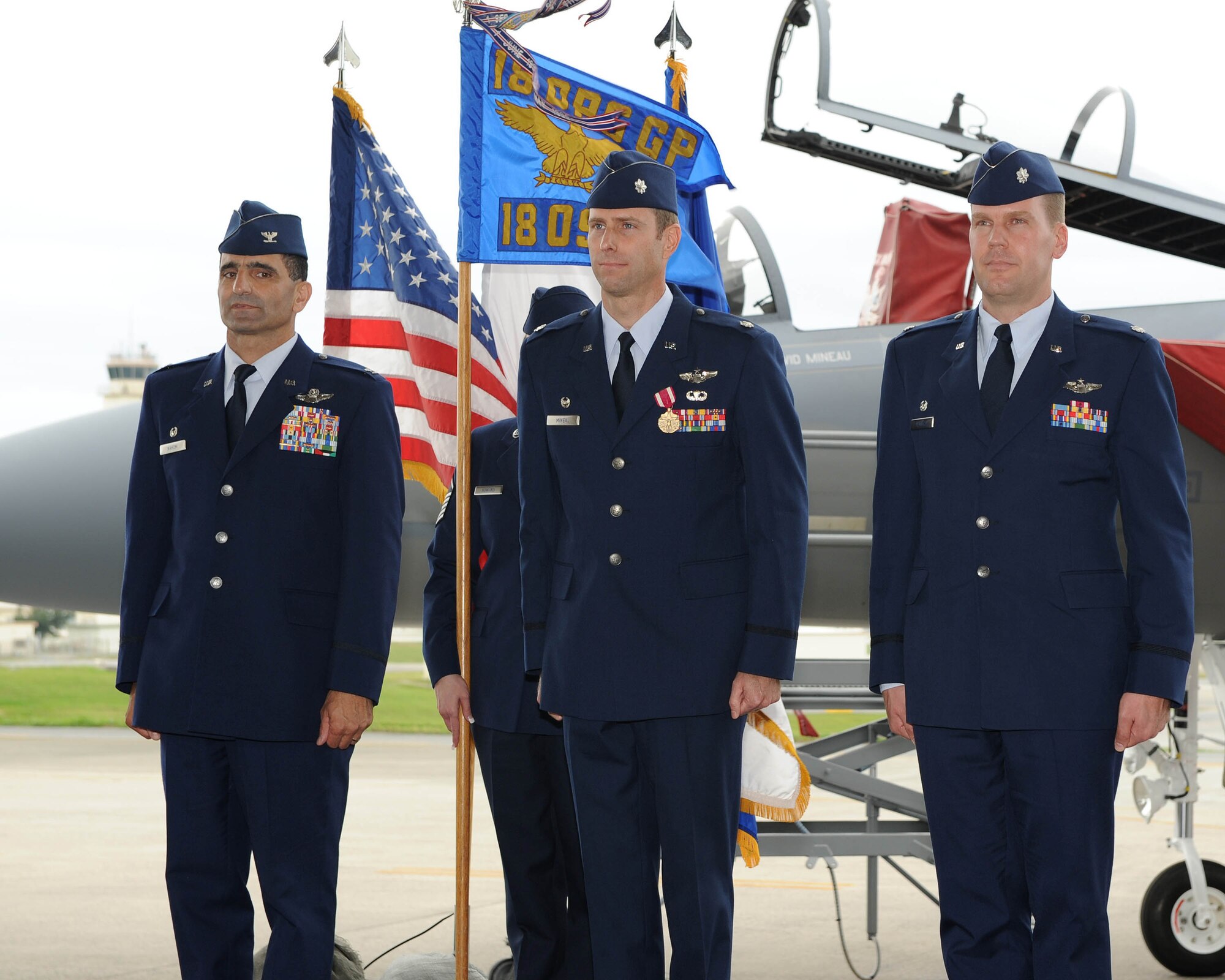 From the left, U.S. Air Force Col. David Nahom, 18th Operations Group commander, stands at attention alongside the outgoing 18th Operations Support Squadron Commander, Lt. Col. David Mineau, and the incoming commander, Lt. Col. Robert Pekarek, during the 18th OSS change of command ceremony on Kadena Air Base, Japan, March 2, 2012. The change of command ceremony is a military formation which is deeply rooted in it's history and tradition and dates back to the time of Frederick the Great of Prussia. 