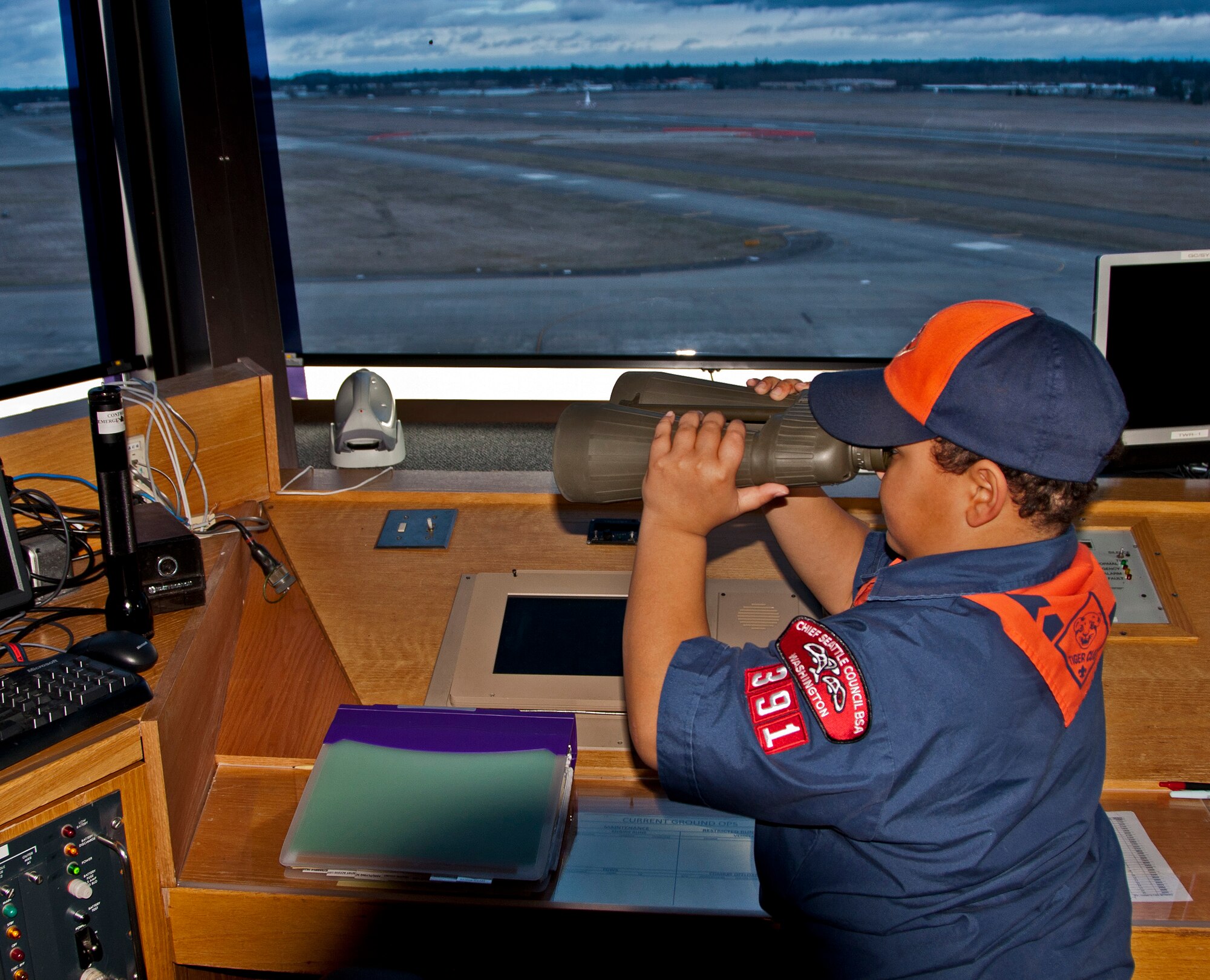 Cub Scout Michael McDade looks through binoculars in McChord Airfield's air traffic control tower during a tour March 3. Parents and scouts from Cub Scout Den 3 Pack 391 of Des Moines, Wash., and Boy Scout Troop 43 of Lake Stevens, Wash., visited the 446th Airlift Wing. They toured a C-17 Globemaster III, the explosive ordinance facility, the air traffic control tower and had a wing mission briefing.  The 446th AW public affairs office hosted the tour as part of its community outreach program.
