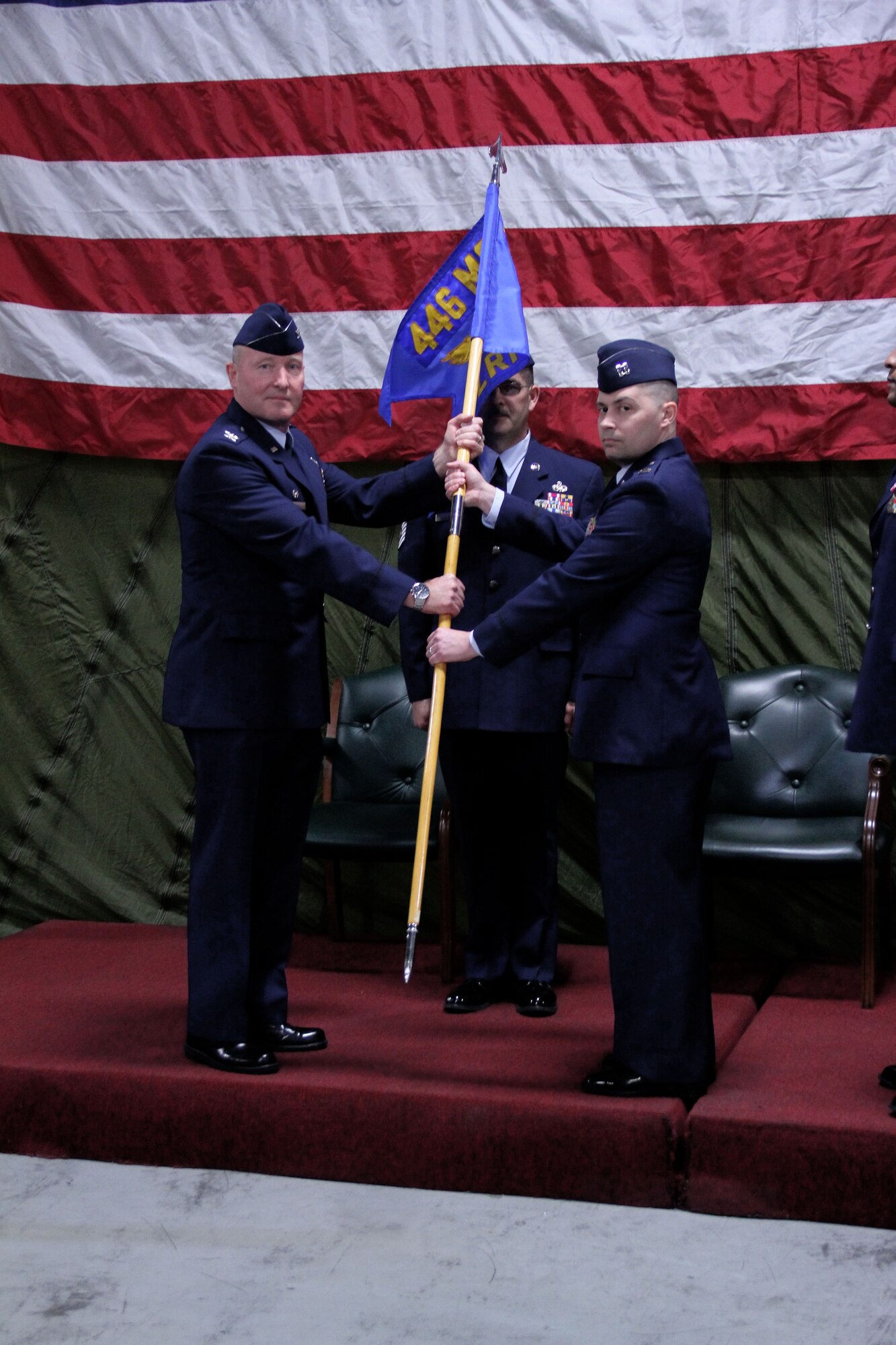 Col. Gerald Vowell, 446th Mission Support Group commander, passes the 446th Logistics Readiness Flight guidon over to its new commander, Capt. Jeffrey Weaver, in a ceremony held at McChord Field's 86th Aerial Port Squadron warehouse March 3.  Weaver replaces former commander, Maj. Tony Edwards, who commanded the flight since April 2008.