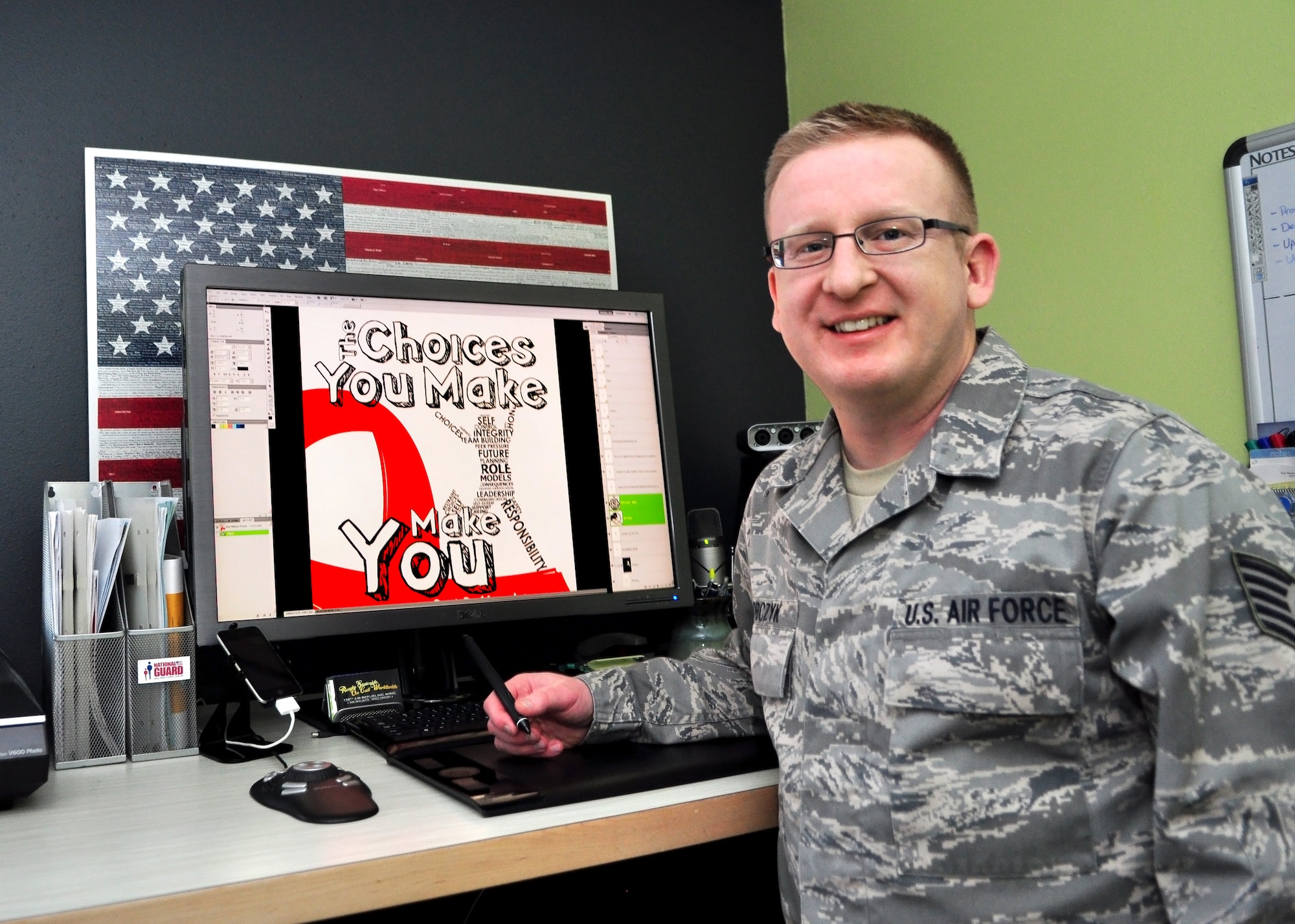 Tech. Sgt. Tom Sobczyk, a multimedia specialist with the Wisconsin National Guard's Drug Control Program, displays the Red Ribbon poster he submitted to this year's National Guard Bureau Media Contest.  The poster was designed was for Red Ribbon Week, an anti-drug campaign that takes place every year in October.  (U.S. Air Force photo by Tech. Sgt. Tom Sobczyk / Released)