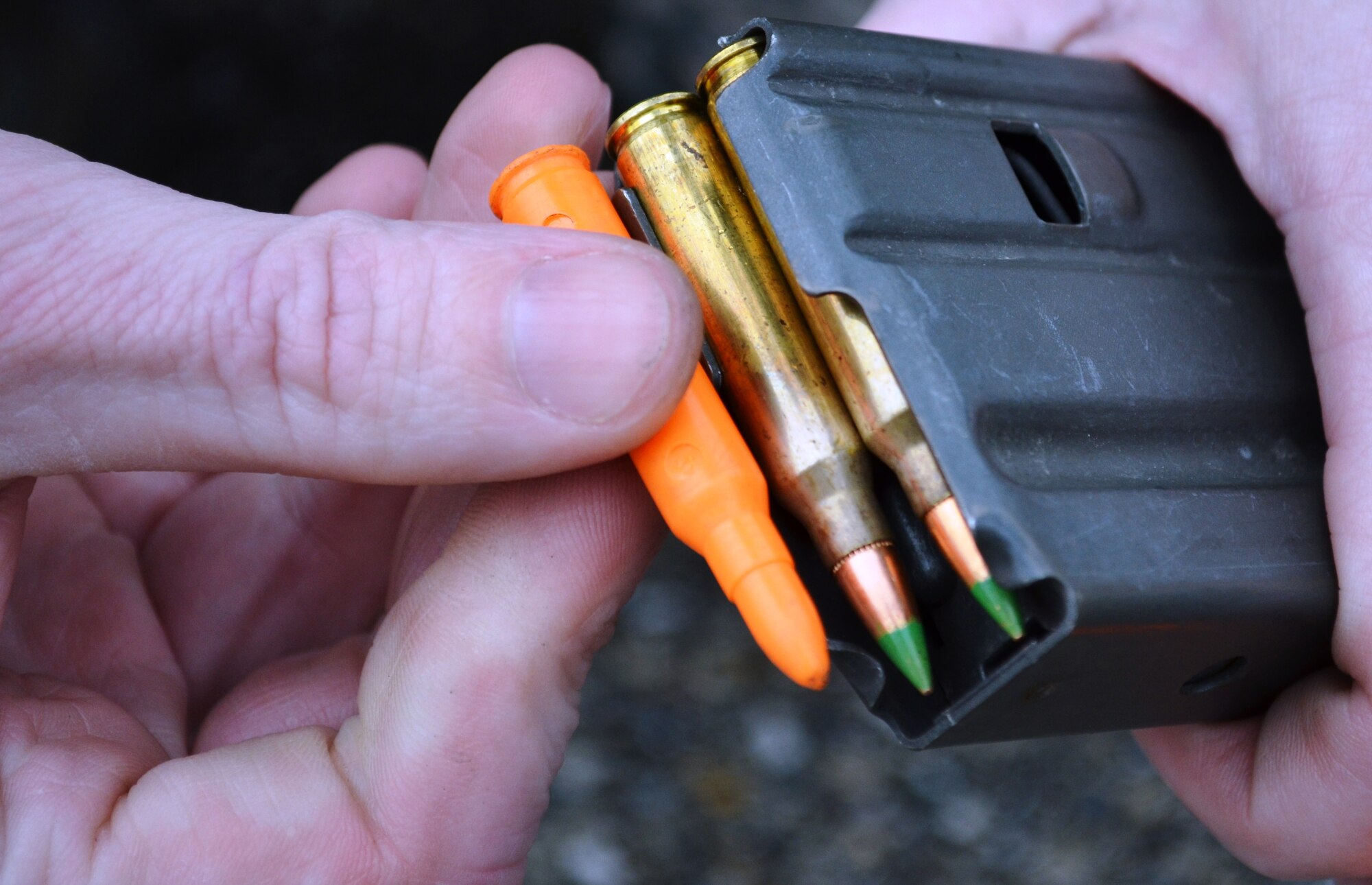 For a new course of fire in small arms qualification, a dummy round is loaded into a magazine. The round will jam in the rifle so that the Airman gains experience in solving the problem of round not firing and needing to be cleared from the gun. The Maryland Air National Guard is in the process of changing the course of fire for small arms qualification which is mandated by the Air Force. (National Guard photo by Senior Airman Rebecca Salazar)