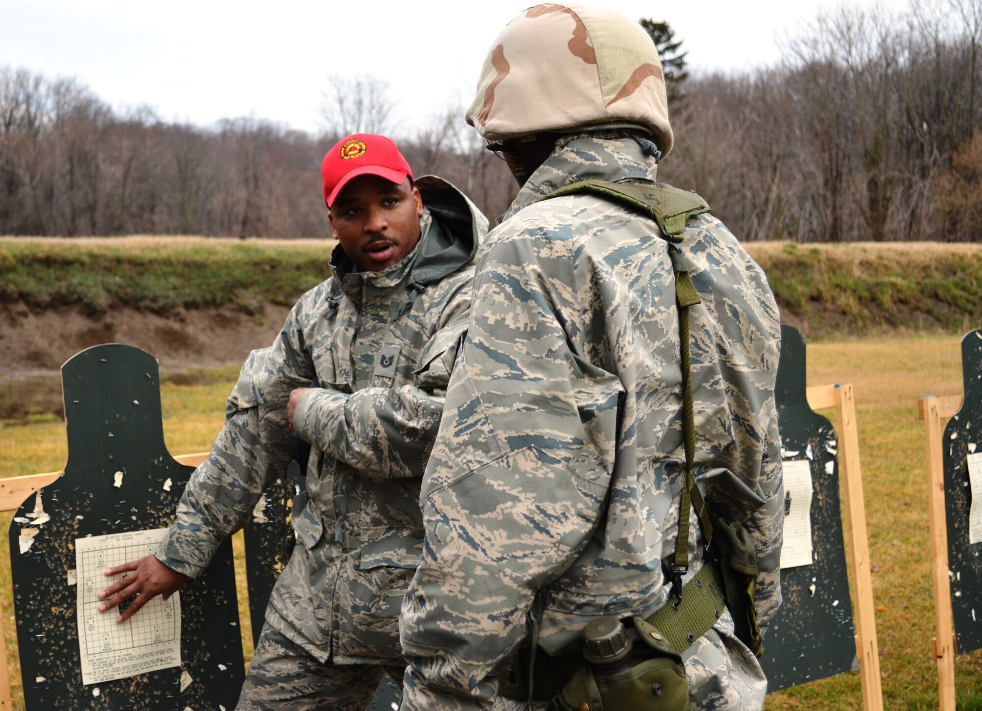 Tech. Sgt. Jerome Howard, left, a combat arms instructor, discusses the grouping pattern of Airman First Class Daniel Generette ’s  shooting on the rifle range at Gunpowder Military Reservation. The Maryland Air National Guard is in the process of changing the course of fire for small arms qualification which is mandated by the Air Force. (National Guard photo by Senior Airman Rebecca Salazar)