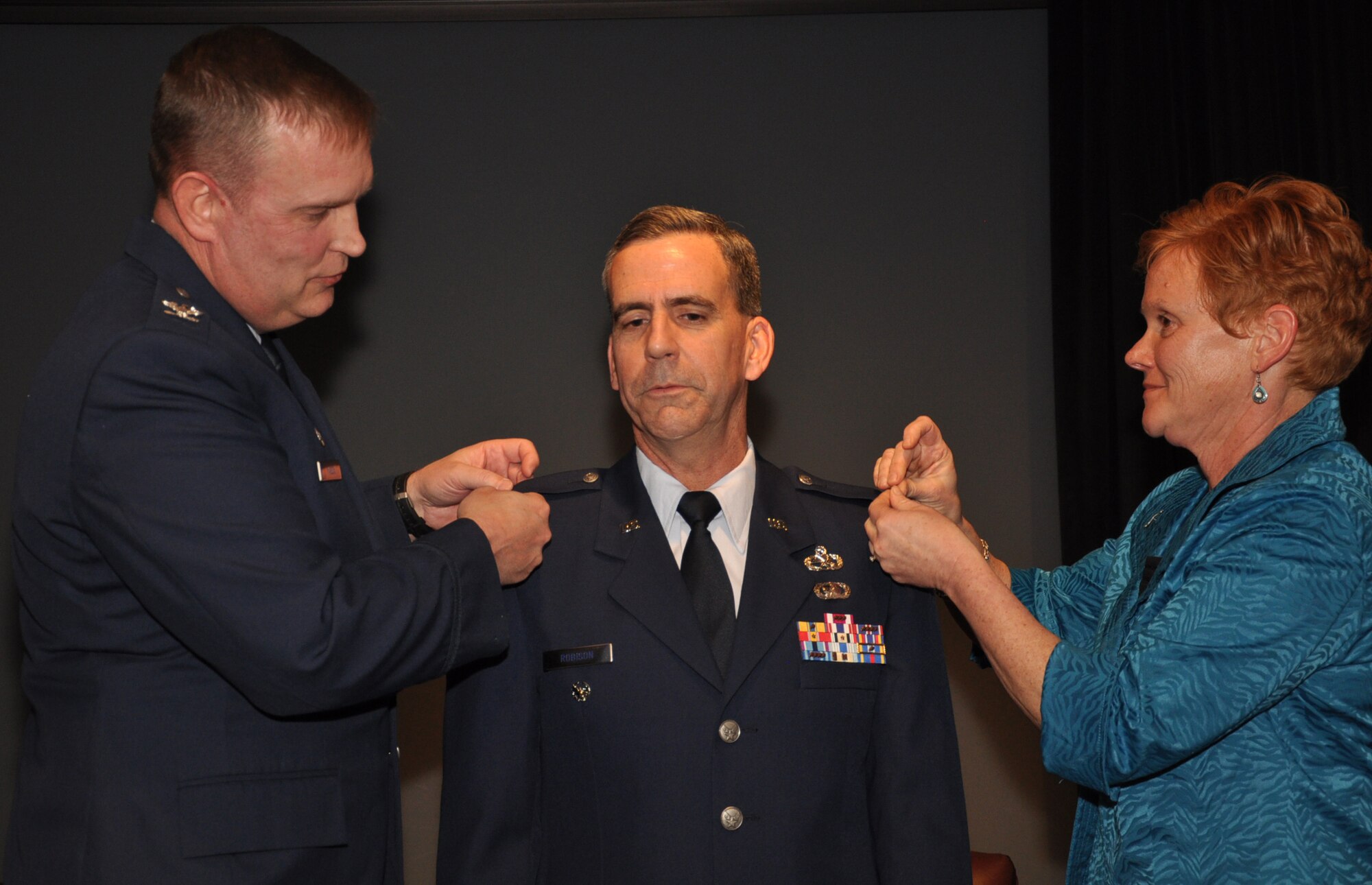Col. Donald Robison, 931st Air Refueling Group Deputy Commander for Maintenance, receives eagle insignia from his wife, Sarah Robison and Col. William H. Mason, Commander, 931st ARG, during a promotion ceremony March 3. Robison is responsible for more than 400 maintainers and support staff assigned to the 931st ARG. (Photo by Tech. Sgt. Brannen Parrish)