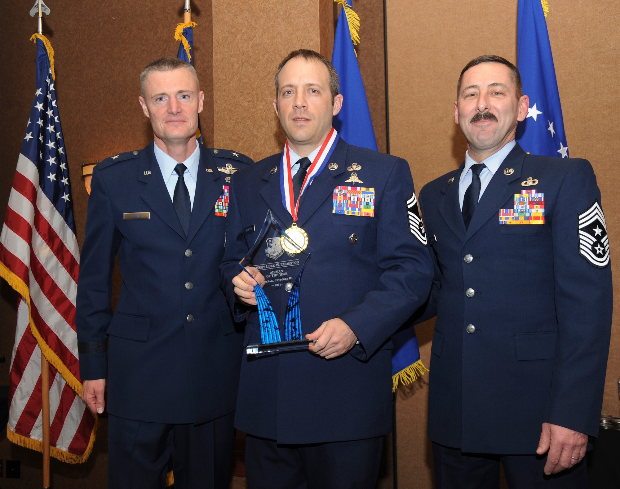 Oregon Air National Guard Commander Brig. General Steven Gregg (left) and Oregon State Air National Guard Command Chief Master Sgt. Mark Russell (far right) stand with Senior Master Sgt. Luke Thompson, who was selected Overall Category III Airman of the Year for the Oregon Air National Guard, during the 18th Annual Oregon Air National Guard Awards Banquet, held on February 25, 2012 in Portland, Ore., (US Air Force Photograph by Tech. Sgt. John Hughel, 142nd Fighter Wing Public Affairs)(Released)