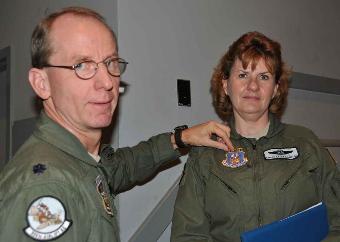 Senior Master Sgt. Kathy Lambert, 326th Airlift Squadron flight leader supervisor and loadmaster instructor, receives her 10,000-hour patch from Lt. Col. David Arthur, 326th AS commander, March 3, 2012, at the theater, Dover Air Force Base, Del. She accumulated more than 10,000 hours of mishap-free flying during her Air Force Reserve career. (U.S. Air Force photo by Staff Sgt. Andria J. Allmond)