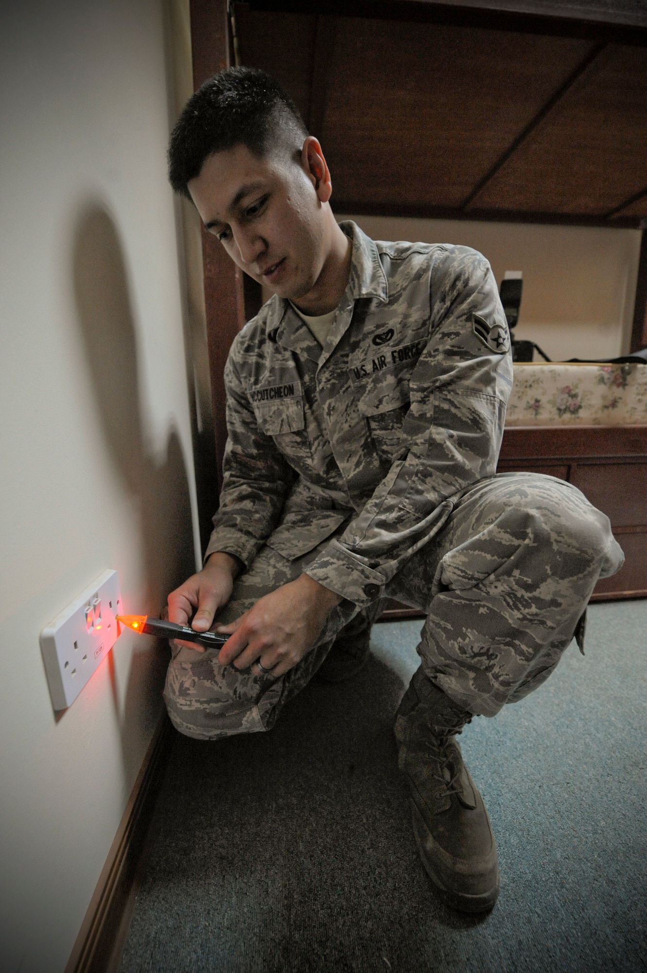 Airman 1st Class Steven McCutcheon, 332nd Expeditionary Civil Engineer Squadron electrician, inspects a power outlet in a dorm room at an undisclosed location in Southwest Asia, Mar. 3, 2012. Dorms were inspected to ensure they were in working order. McCutcheon is deployed from Dover Air Force Base, Del., and is a native of Barlow, Ohio. (U.S. Air Force photo by Staff Sgt. Joshua J. Garcia/Released)

