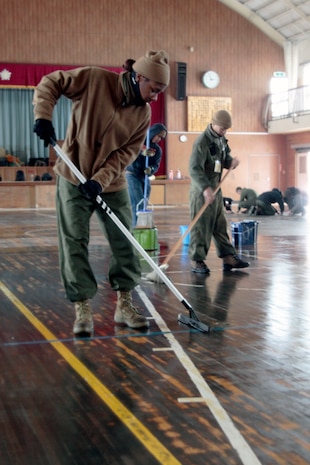 Marine Corps Air Station Iwakuni volunteers mop and squeegee the Minato Shogakko (Elementary School) gym floor here March 5. The gym had been used as a shelter for locals in the aftermath of the earthquake and tsunami which struck this area of Japan March 11, 2011.